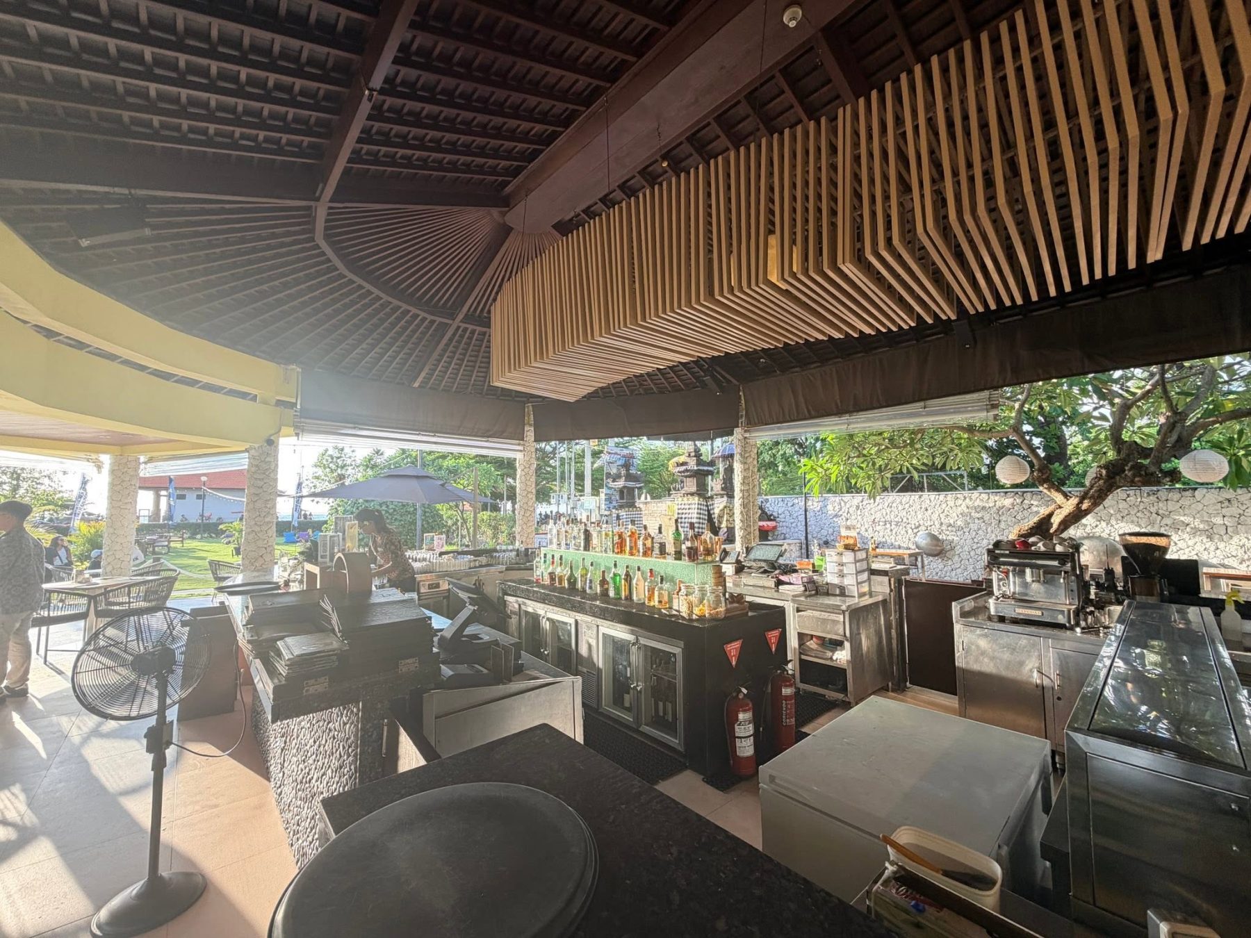 峇里島 Holiday Inn Baruna ENVY 吧台酒架、咖啡機與戶外草坪