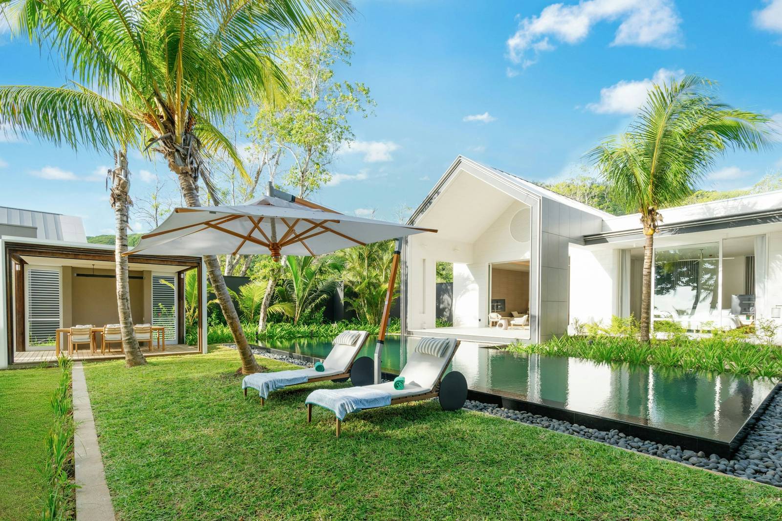 塞席爾白馬莊園 Beach Retreat Villa 的草坪、泳池與躺椅