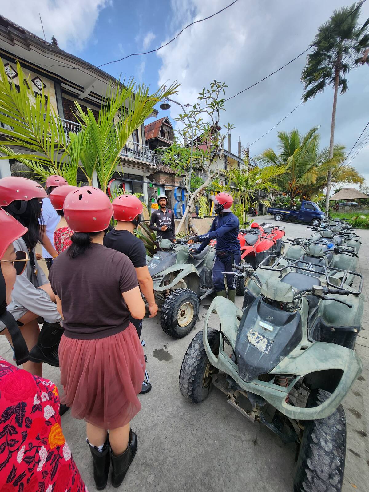 參加者戴著紅色安全帽在 Kuber Bali Adventure ATV 車隊旁等候出發