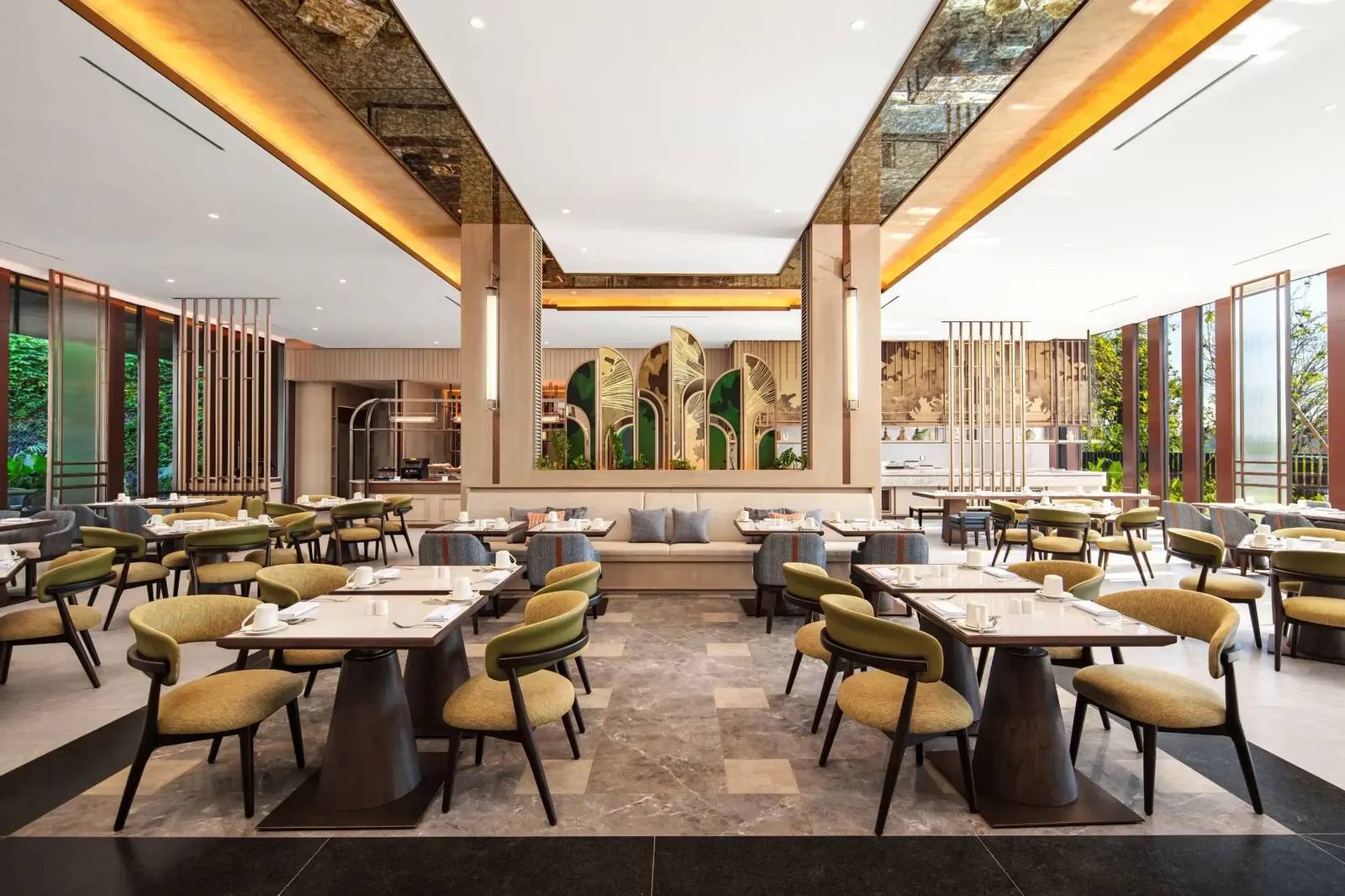 Crowne Plaza Labuan Bajo Pamakka 全日餐廳的桌椅、中央卡座與金色扇形隔屏