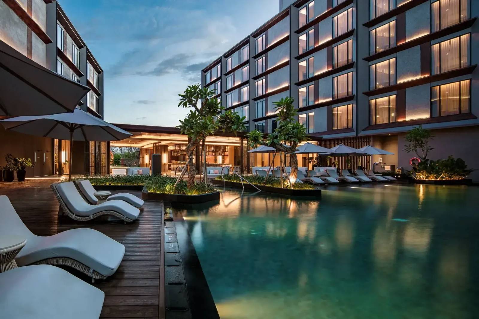 Crowne Plaza Labuan Bajo 黃昏戶外泳池、躺椅與後方客房樓
