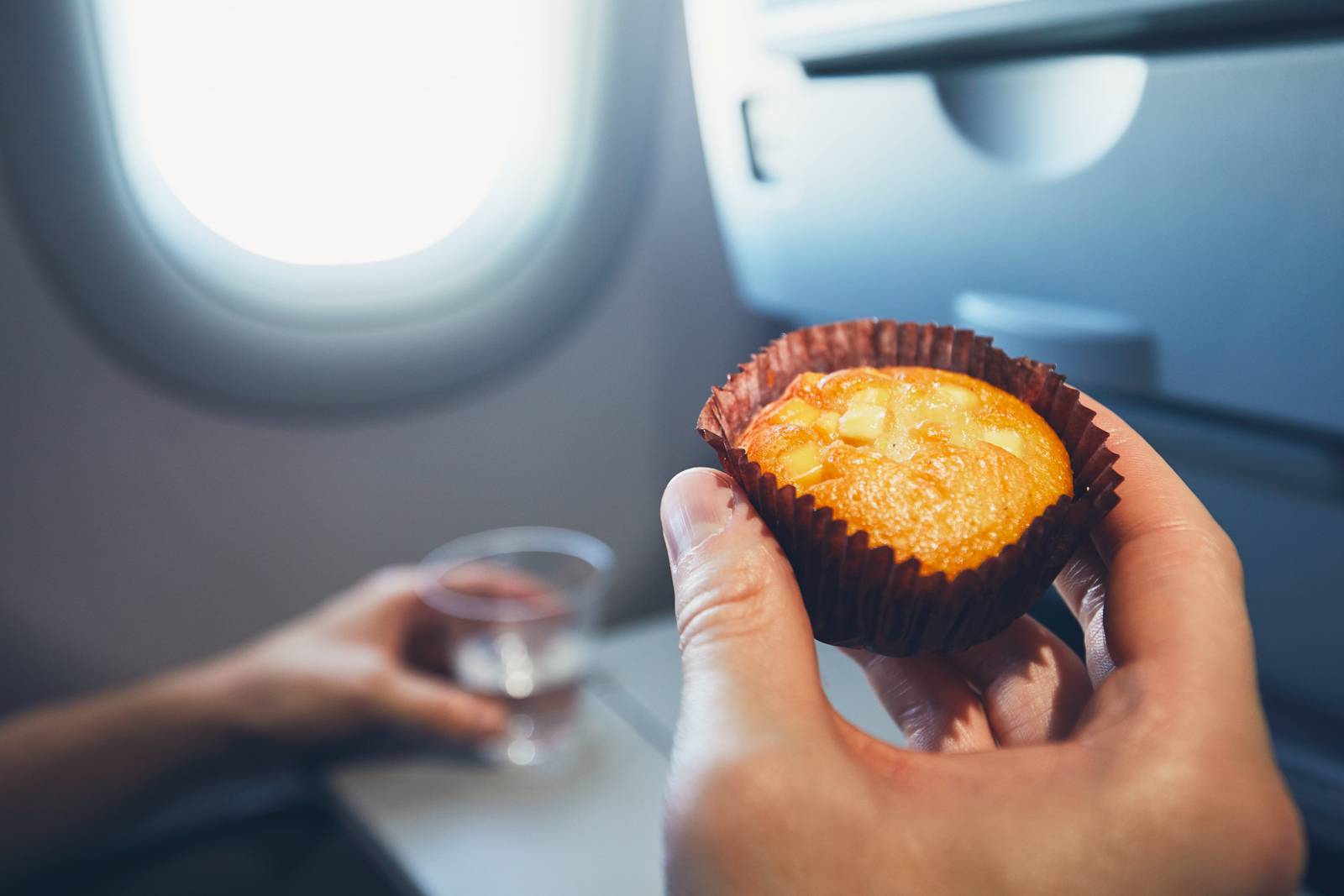 旅客在飛機窗邊享用點心與飲料