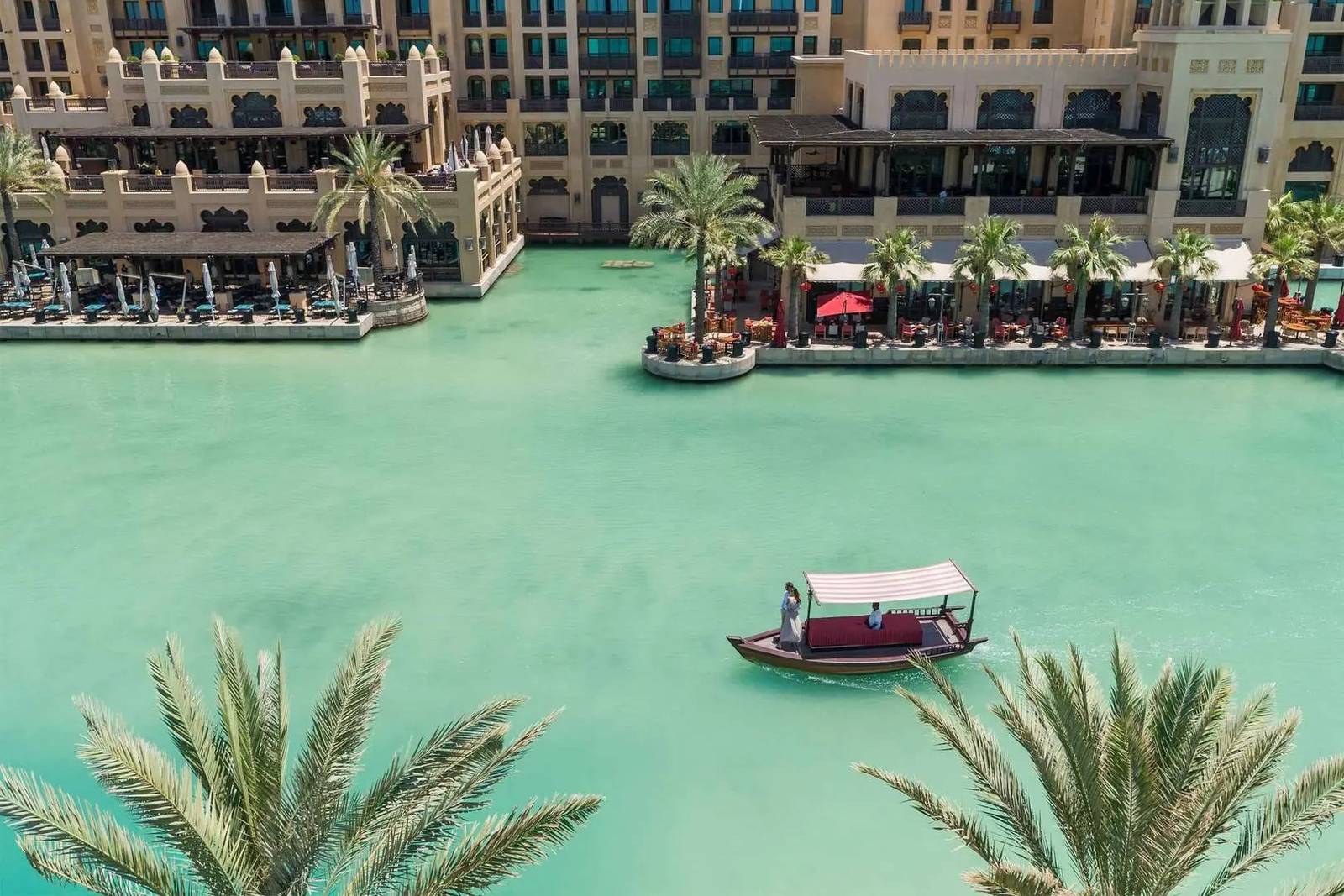 Madinat Jumeirah 水道上的傳統 abra 木船與棕櫚樹