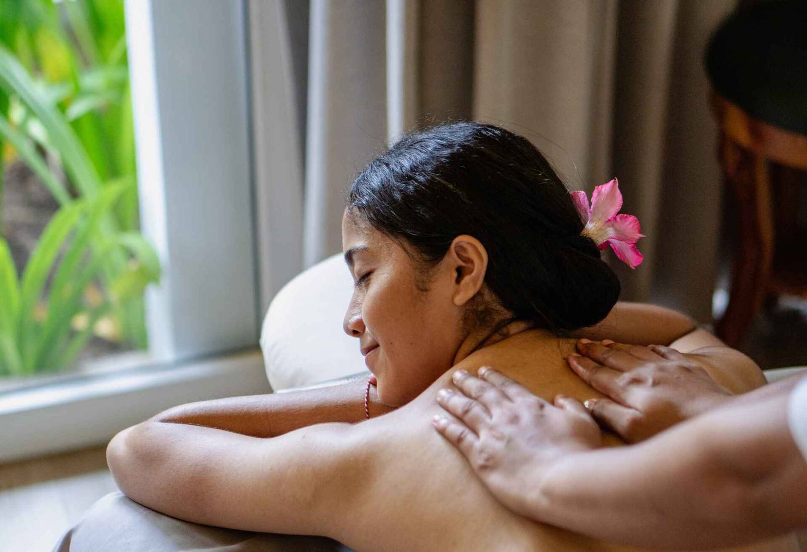 Sudamala Seraya 按摩床上的人與窗口外的熱帶葉