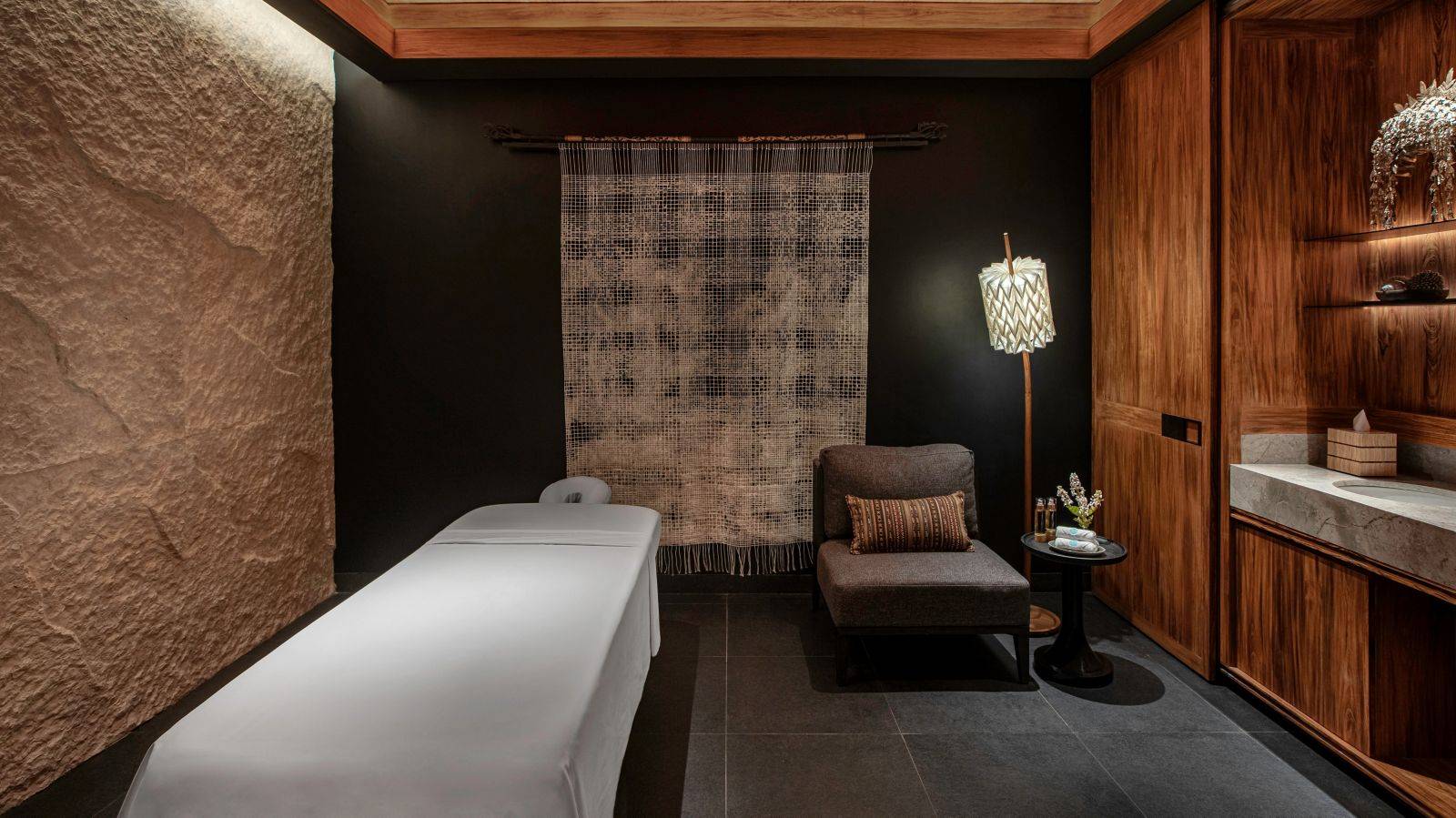 TA’AKTANA Di’a Spa 單人護理室的按摩床與石牆