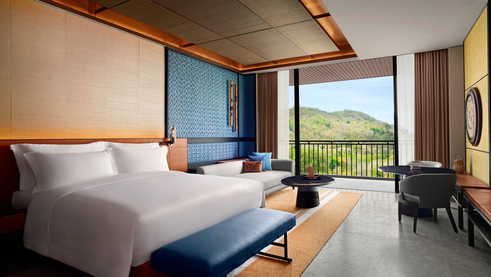 TA’AKTANA Junior Suite 大床、藍色抱枕與窗邊座椅