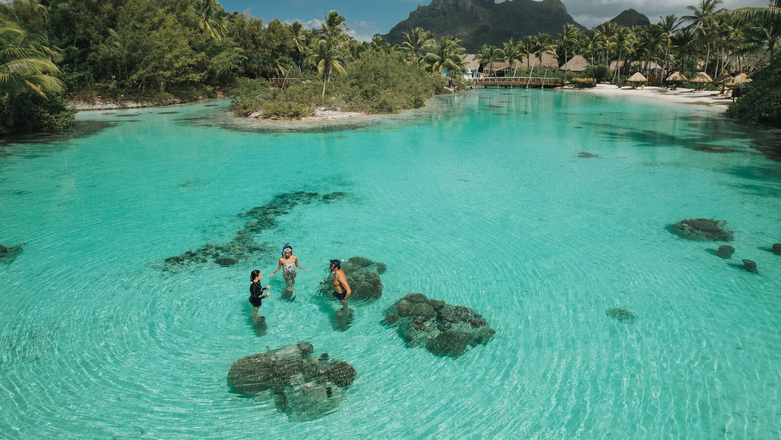 家庭旅客在波拉波拉清澈潟湖中進行水上活動