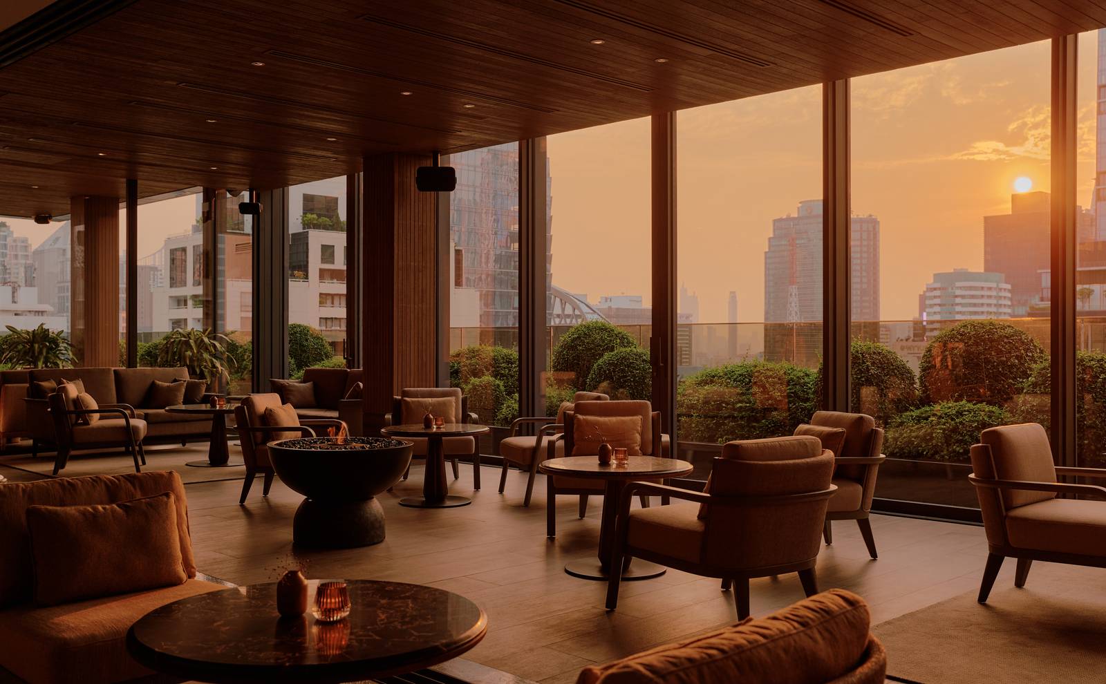 Aman Lounge 的座位區與黃昏時的市區天際線