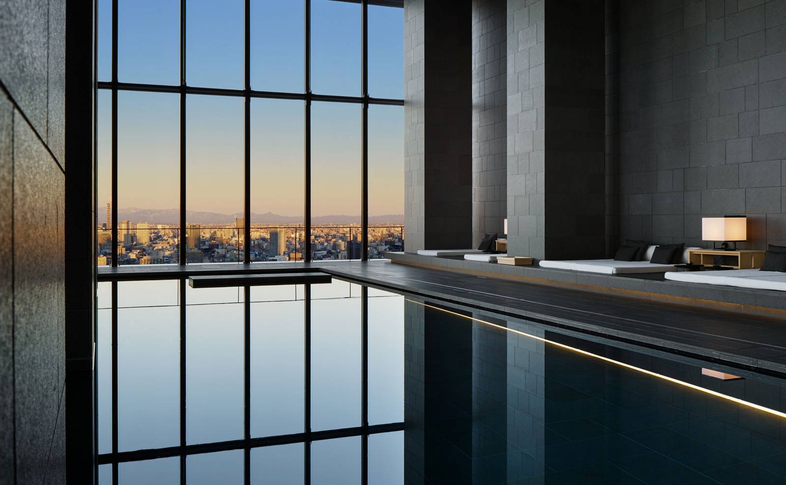 室內泳池的水面與黃昏時的城市窗景