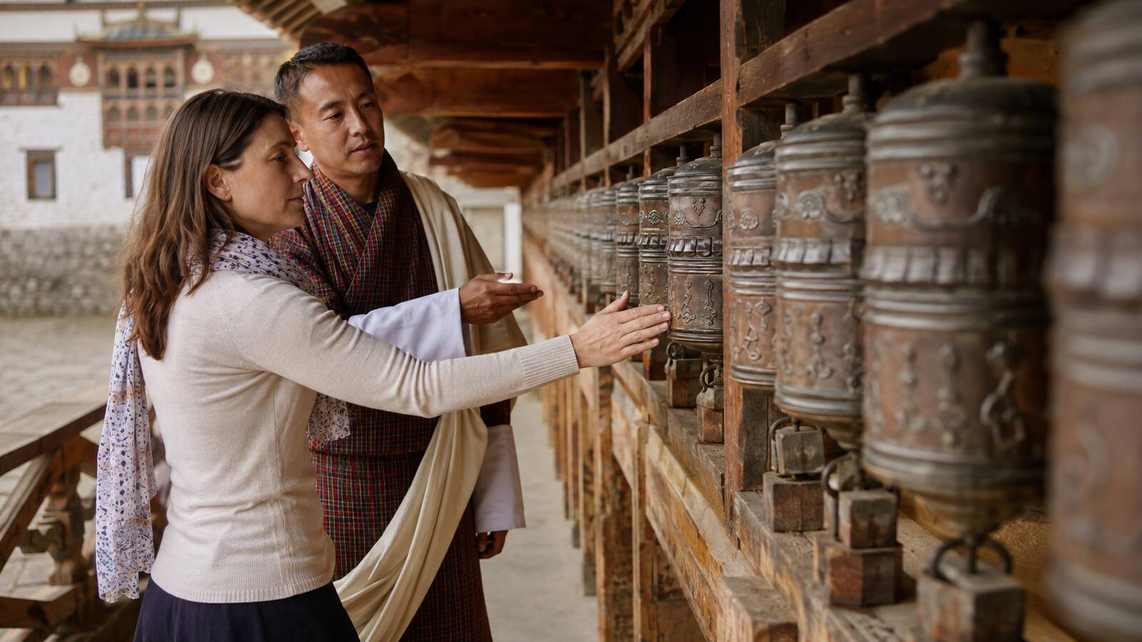 旅客在不丹導遊說明下依序轉動寺院外的轉經輪