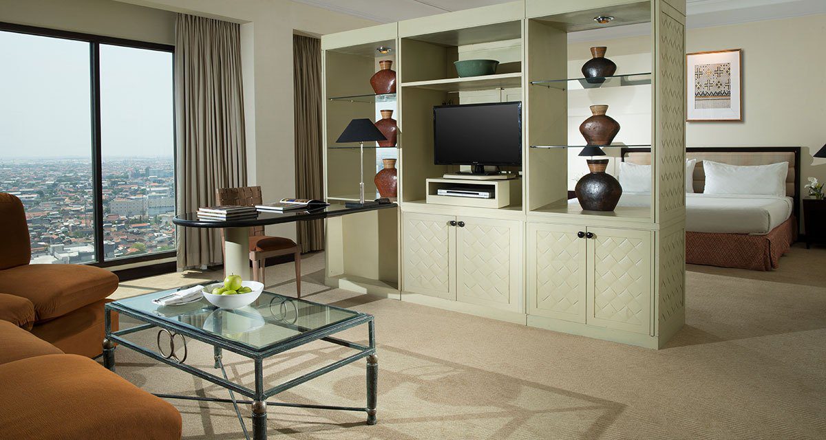 Classic Suite Room 以中央櫃體分隔起居區與臥室，落地窗外為城市景觀