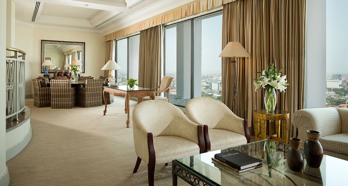 Classic Penthouse 的起居空間，設有沙發座位區與可俯瞰城市的整面落地窗