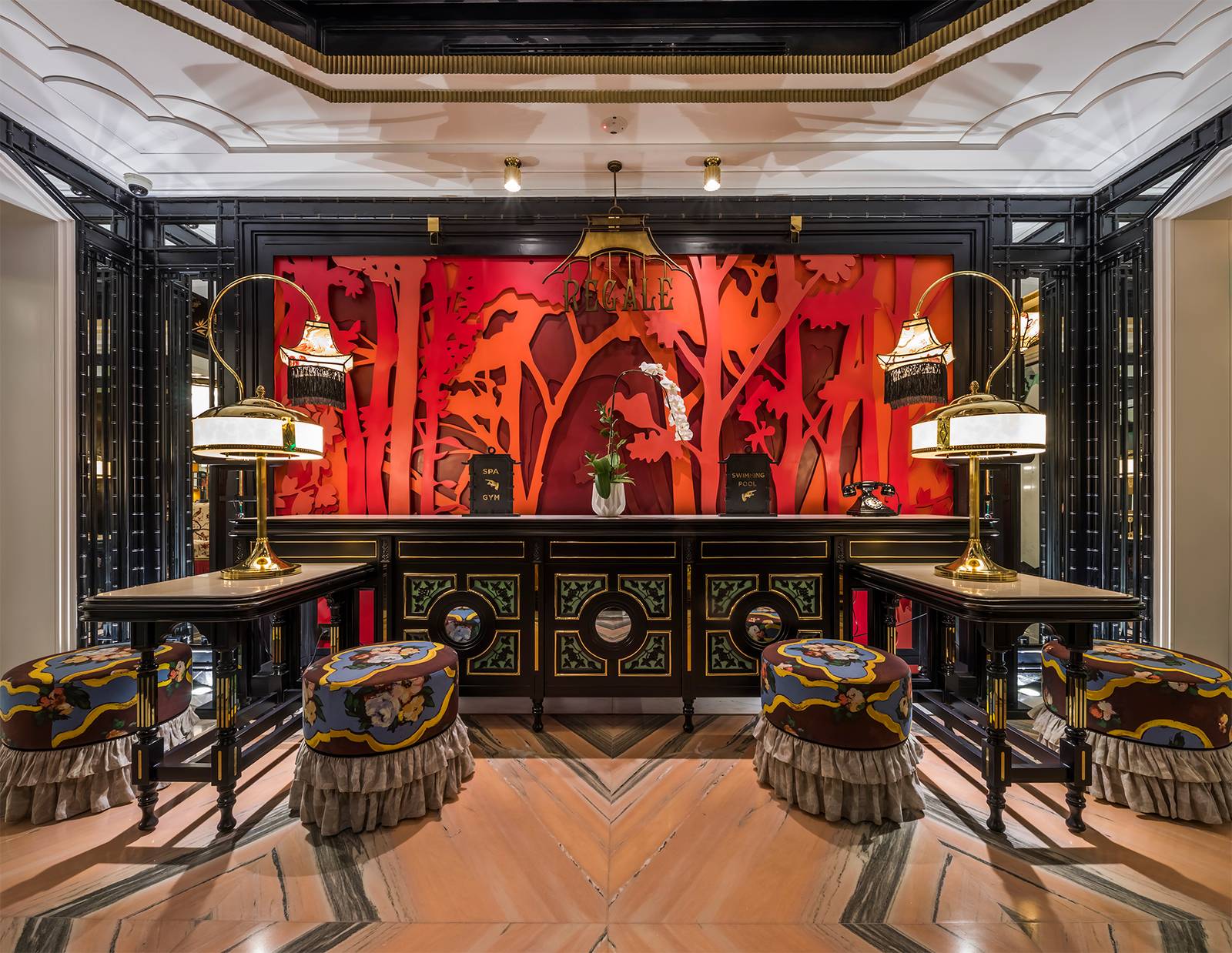 河內嘉佩樂酒店 Regale 接待台,紅底剪影牆與 SPA GYM、SWIMMING POOL 立牌