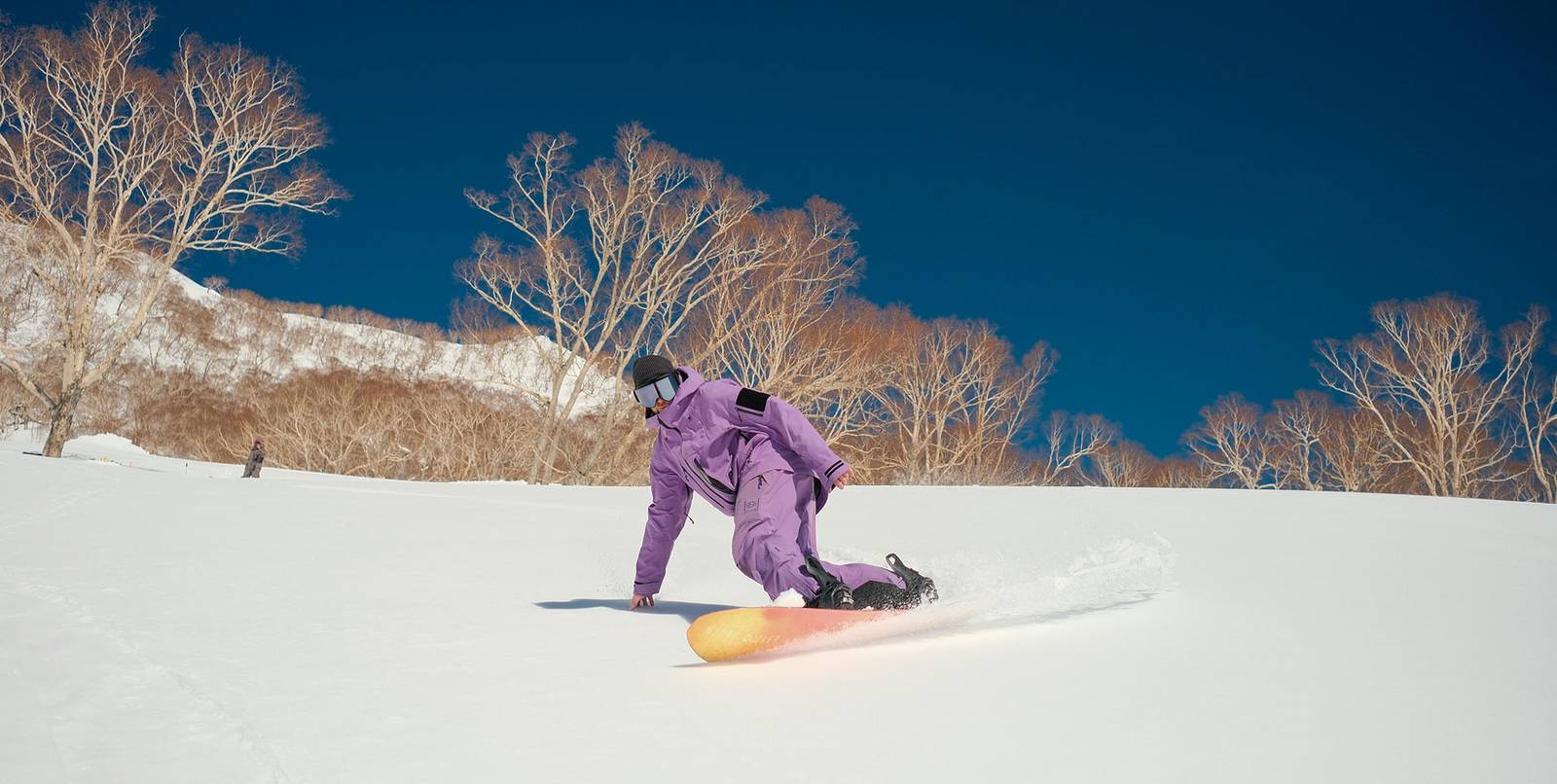 二世古粉雪林間滑降的單板滑雪者