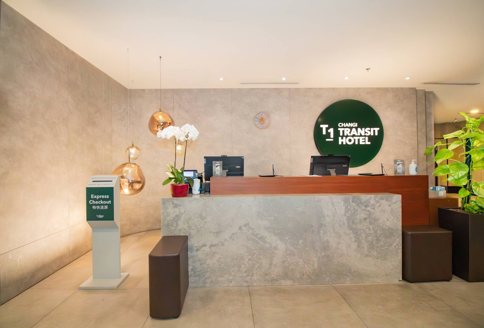 T1 CHANGI TRANSIT HOTEL 櫃台、綠色圓形招牌與特快退房立牌