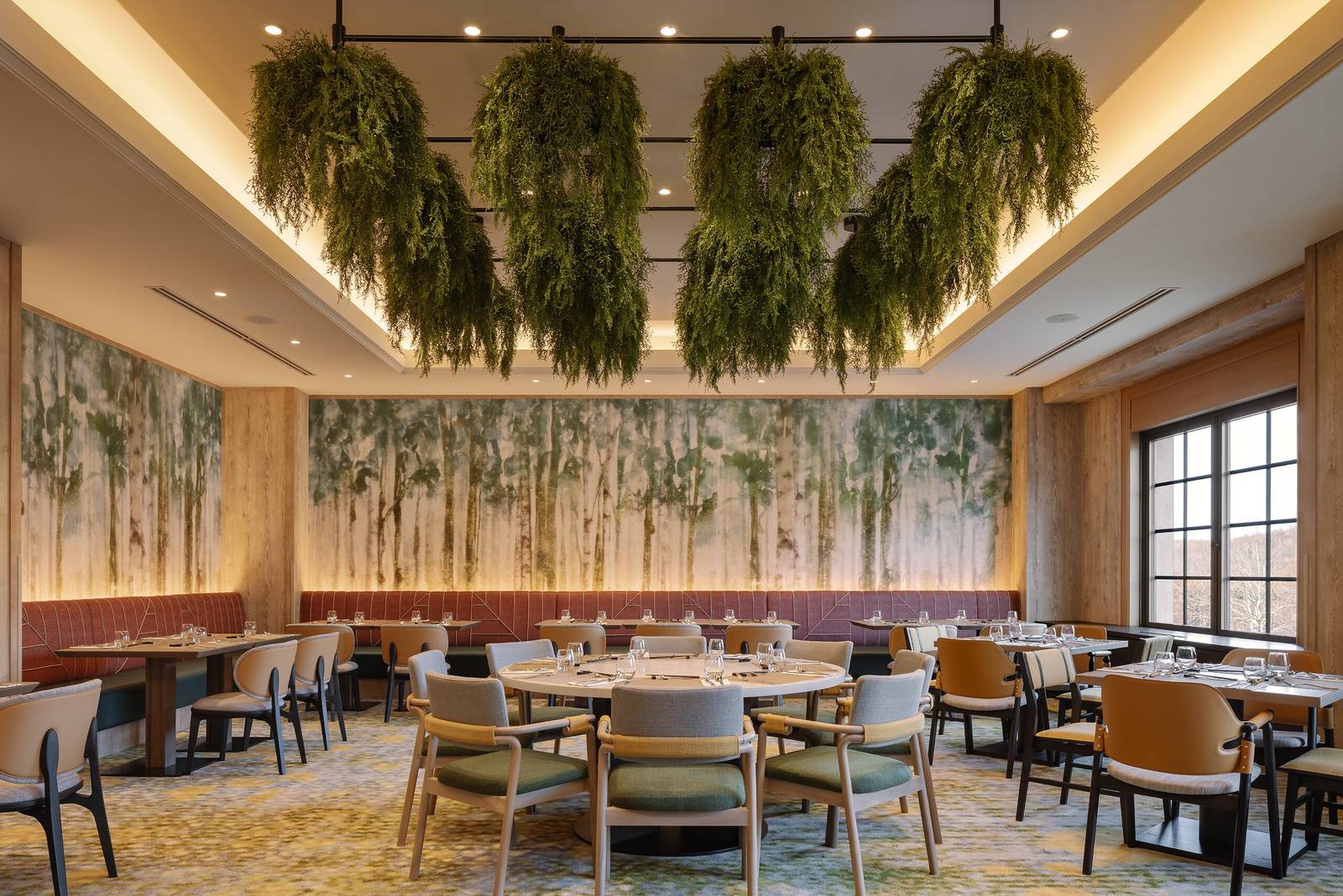 主餐廳的吊掛植栽、餐桌與森林主題壁畫