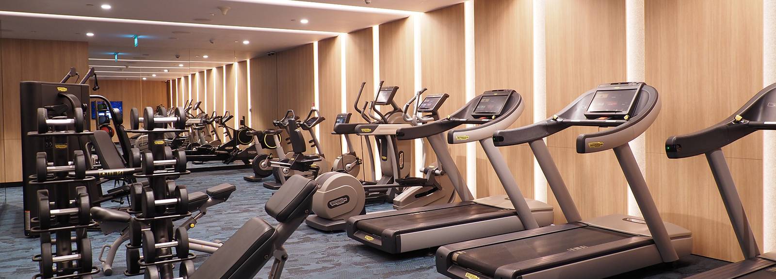Crowne Plaza Changi Airport 健身中心跑步機、重量器材與木質牆面