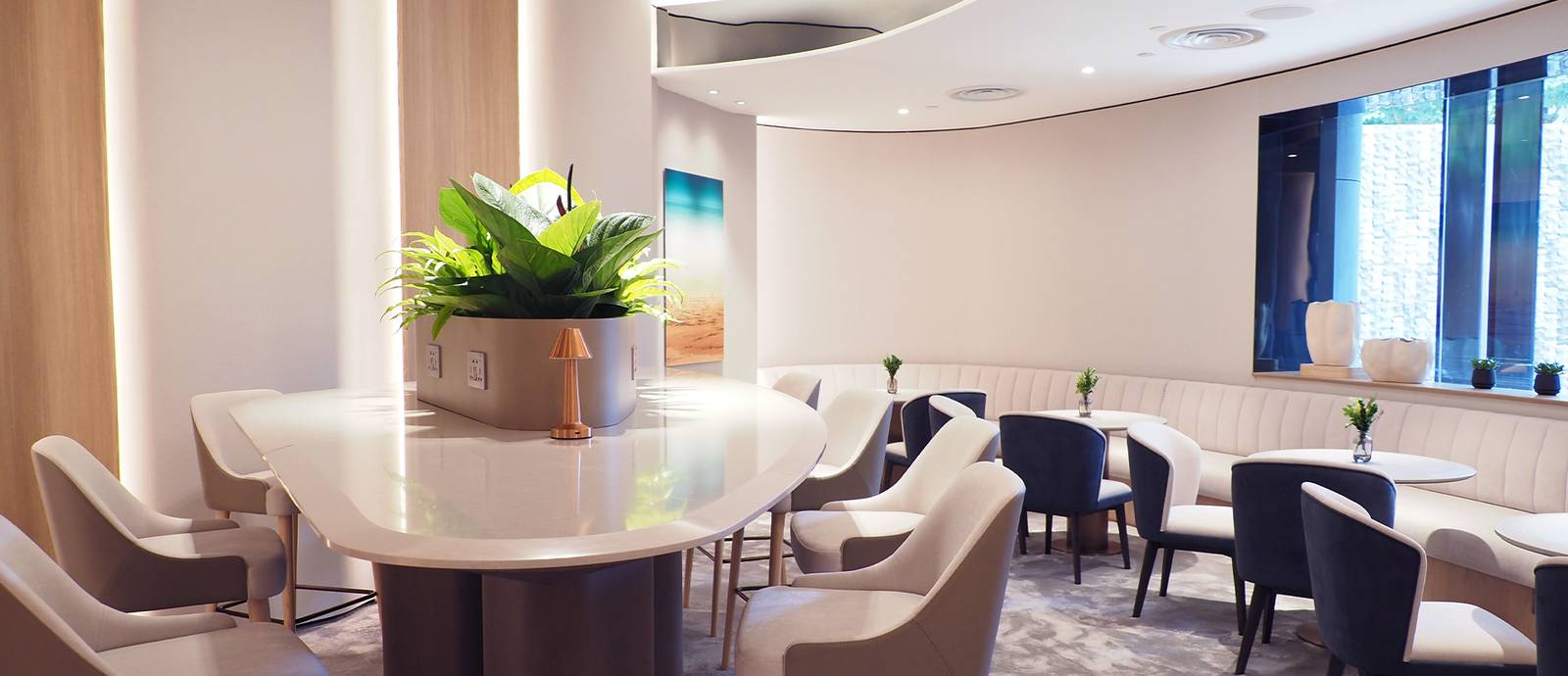 Club Lounge 中央長桌、藍色座椅與窗邊卡座