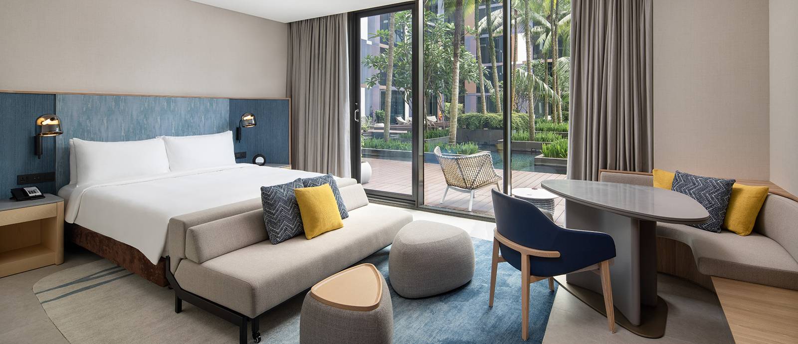 Crowne Plaza Changi Airport 客房大床、沙發與落地窗外的花園水景