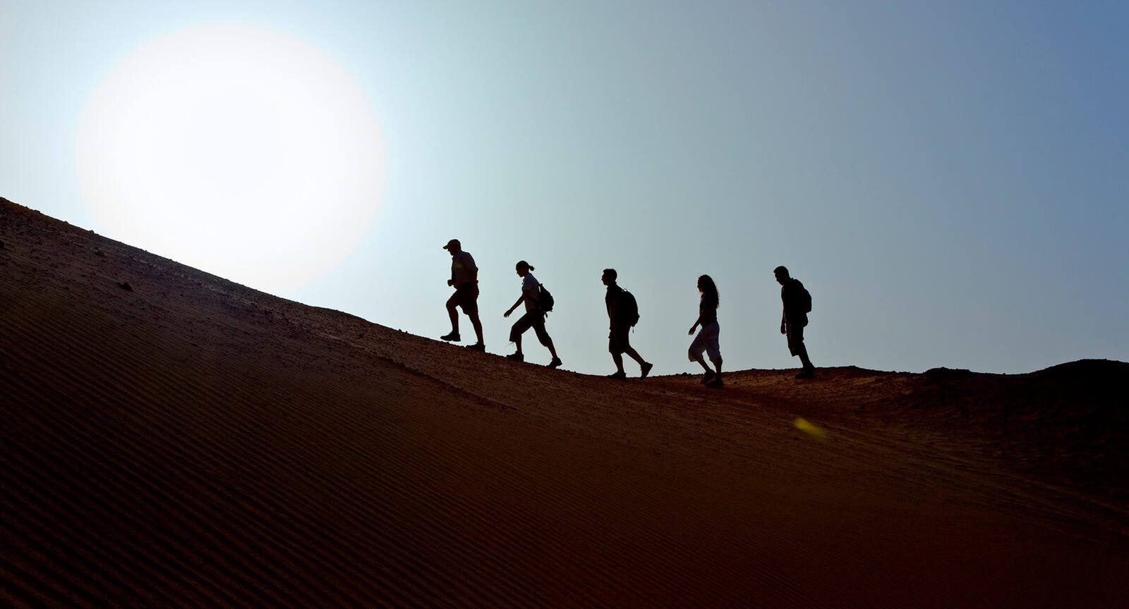 Sir Bani Yas 島沙丘上的健行隊伍剪影