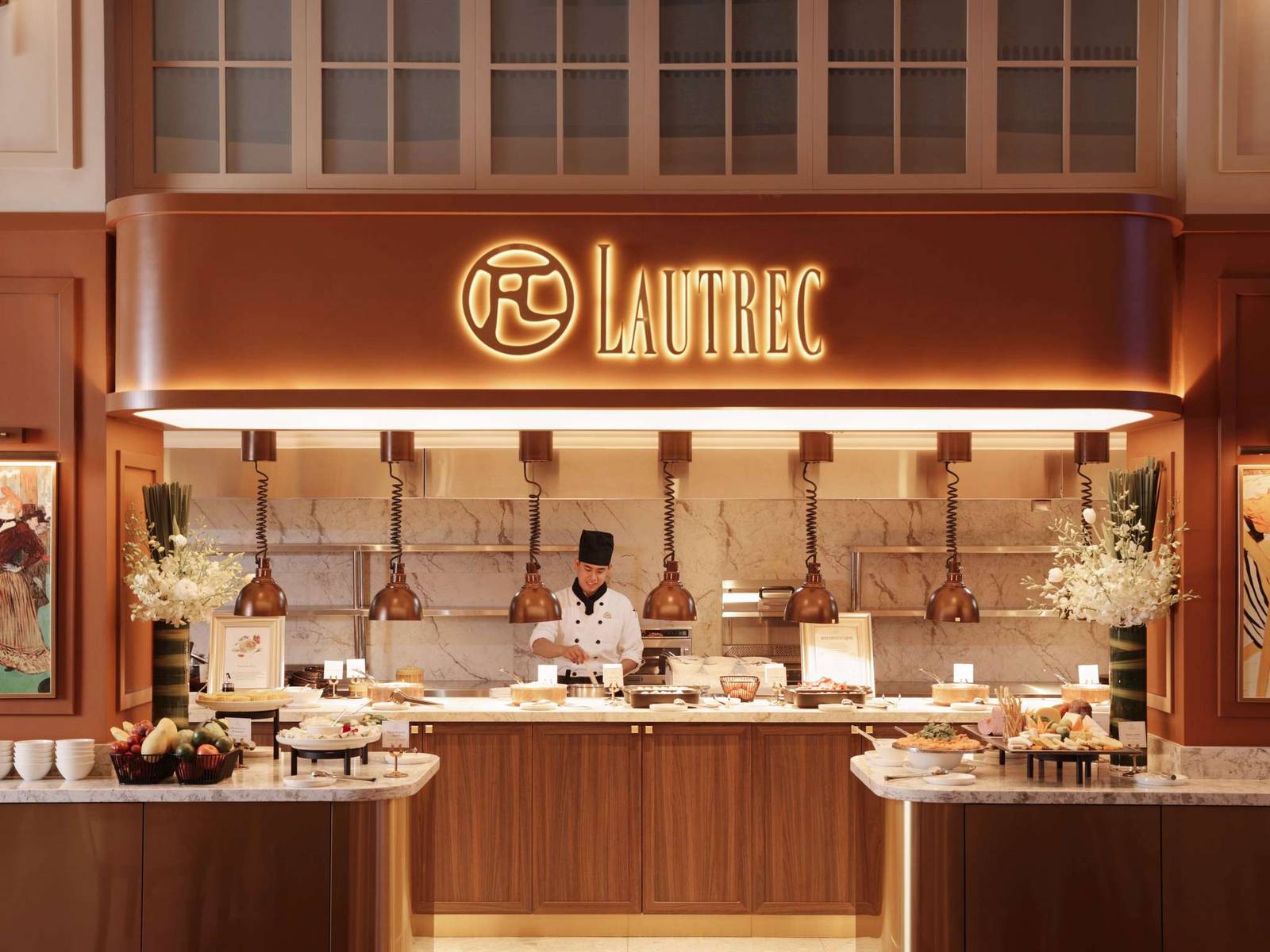 河內歌劇院酒店 Lautrec 餐檯，銅燈、白色大理石檯面、廚師與 LAUTREC 發光字