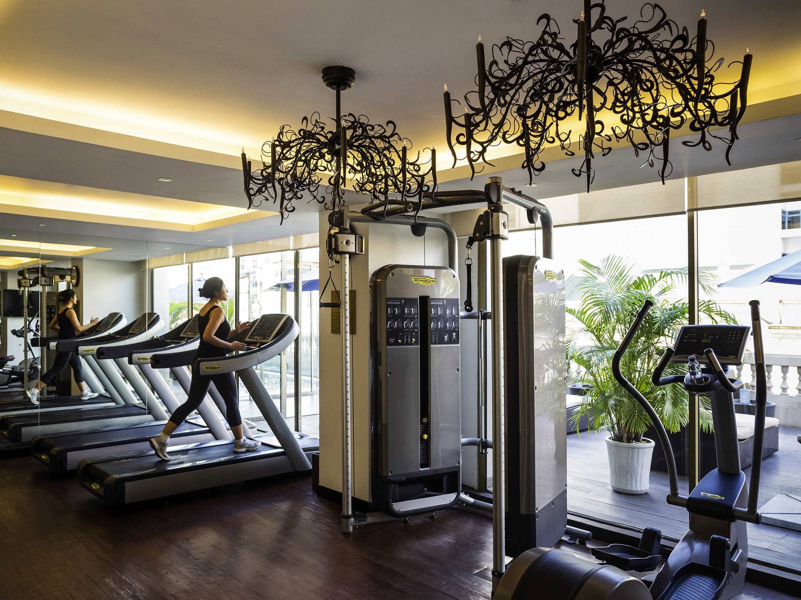 河內歌劇院酒店健身房，Technogym 跑步機、鍛鐵吊燈與窗外露臺