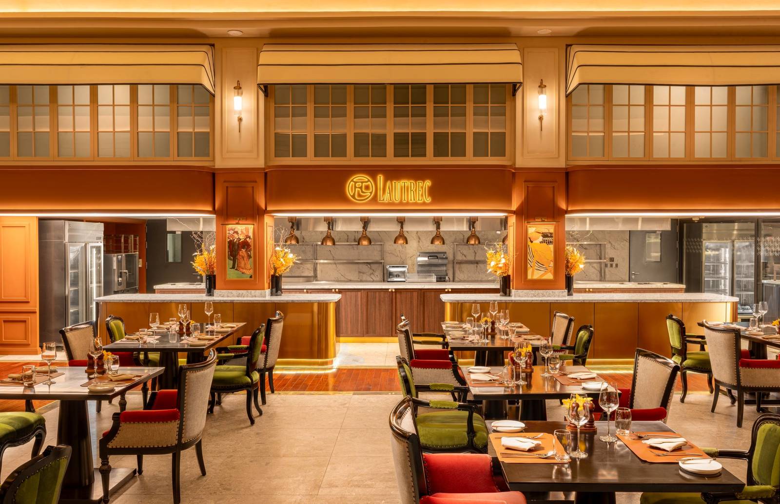 河內歌劇院酒店 Café Lautrec 餐廳，深色餐桌、紅綠絨椅與後方開放式廚房招牌