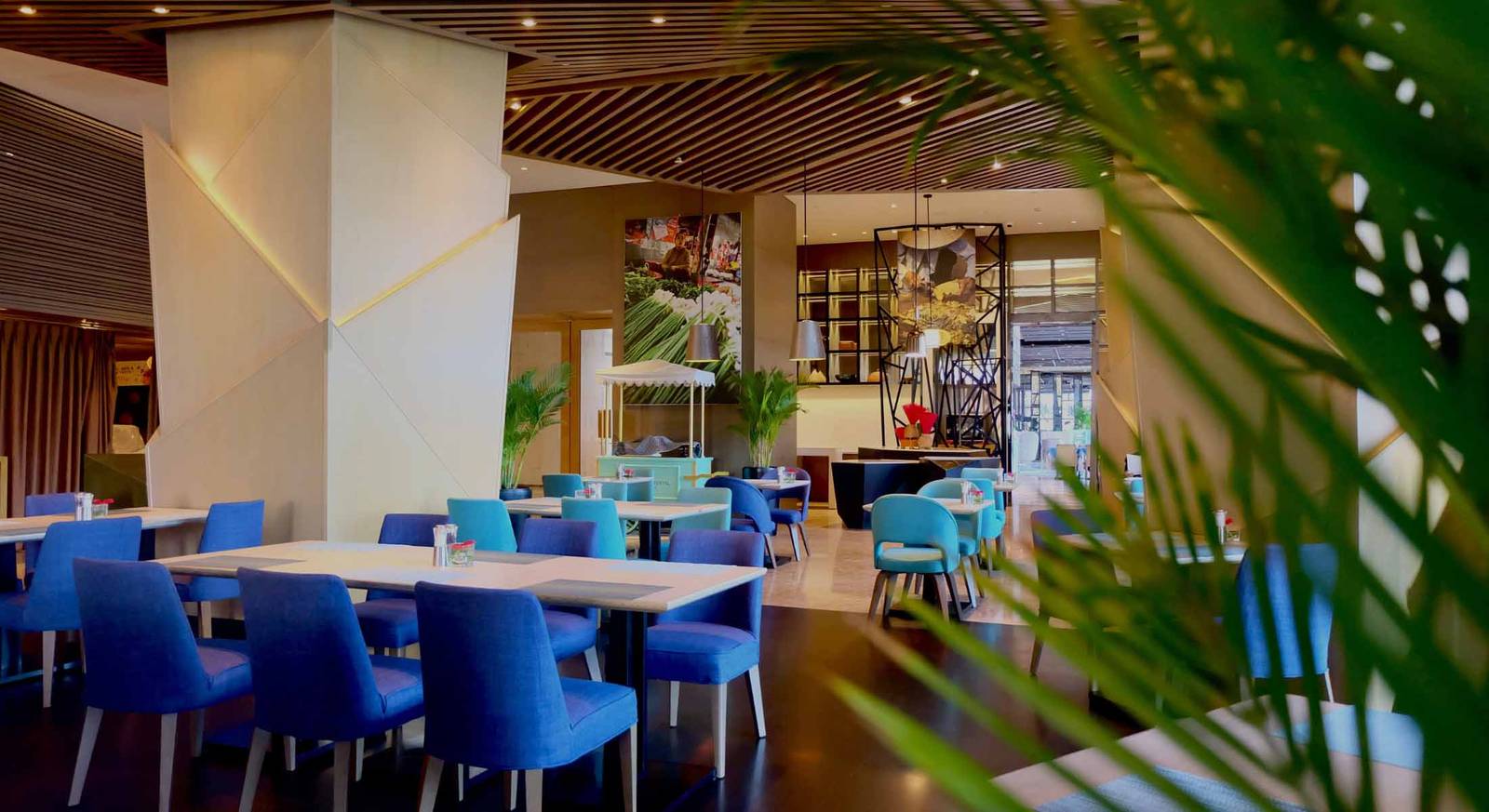 芽莊洲際酒店 Cookbook Café 日間餐區有寶藍與青綠座椅、幾何白柱與木質天花