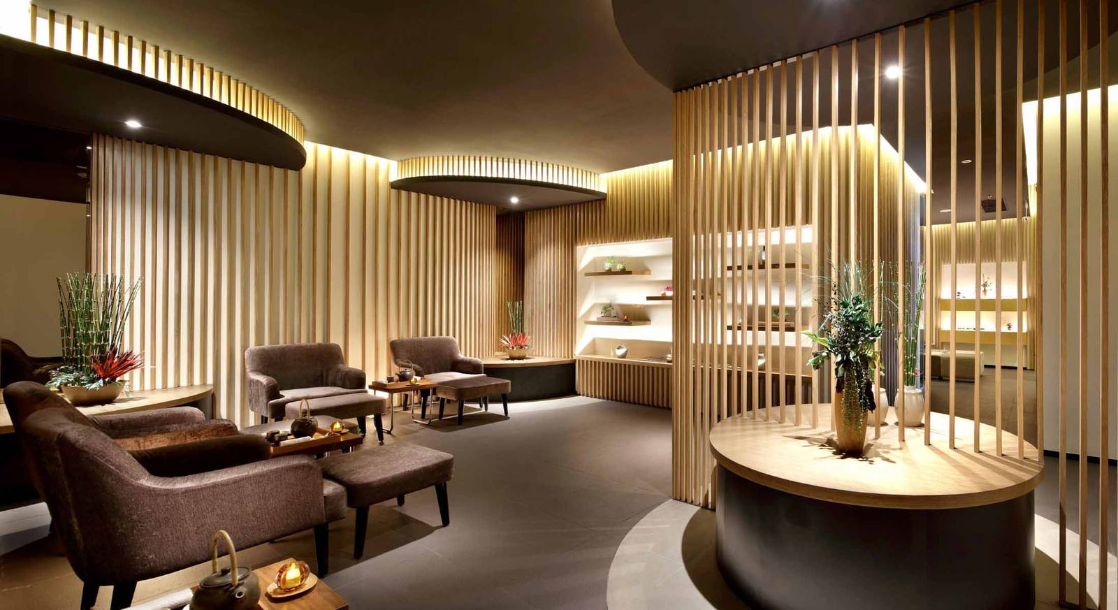 芽莊洲際酒店 The Spa Nha Trang 休息區有木格柵、高背椅、茶具與暖色間接照明
