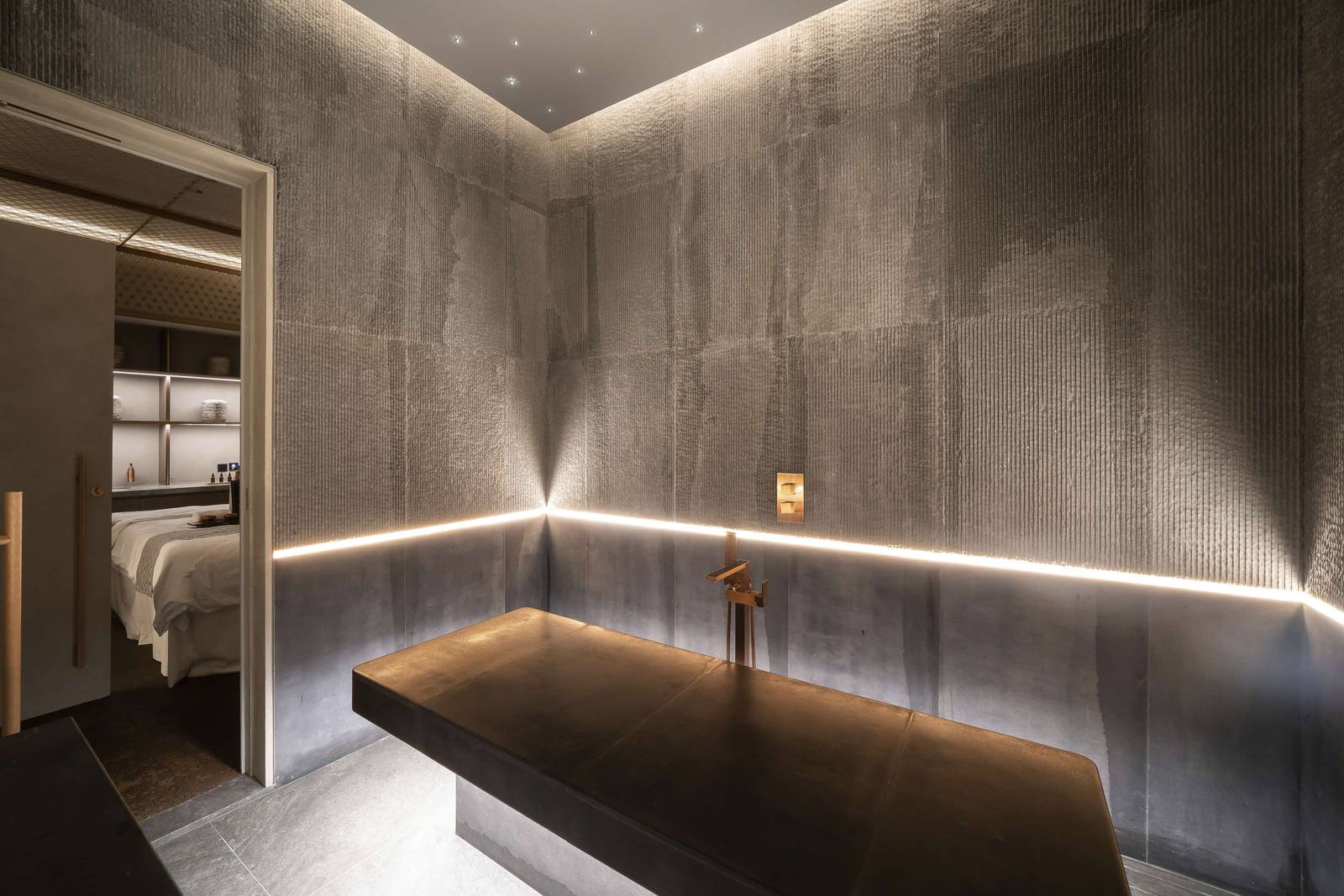 Spa 療程室內的按摩床與石質牆面