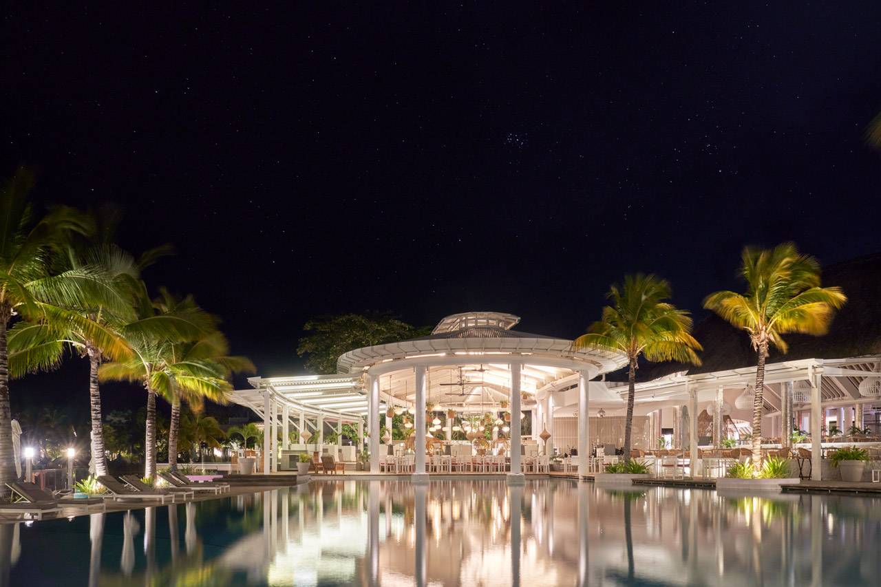 模里西斯 LUX* 格蘭德高布度假村夜間燈光與水面倒影環繞的 Palm Court