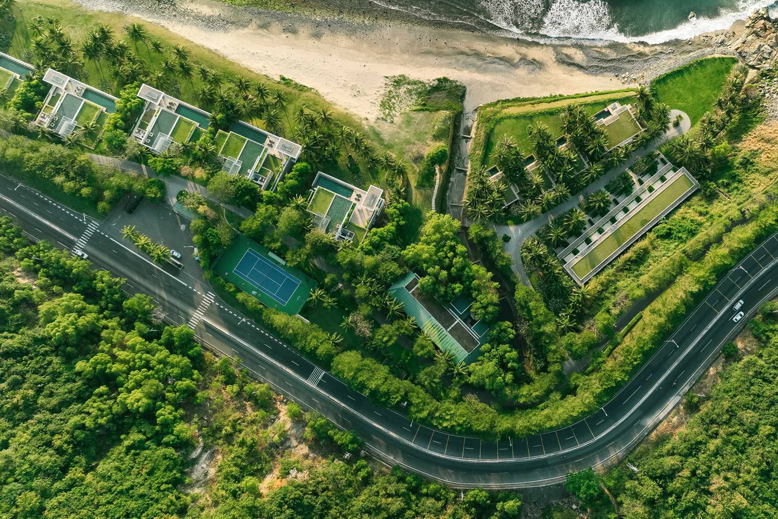 芽莊 Mia 度假村沿崖岸與沿海道路展開的低層別墅群空拍,東側為私灣海面