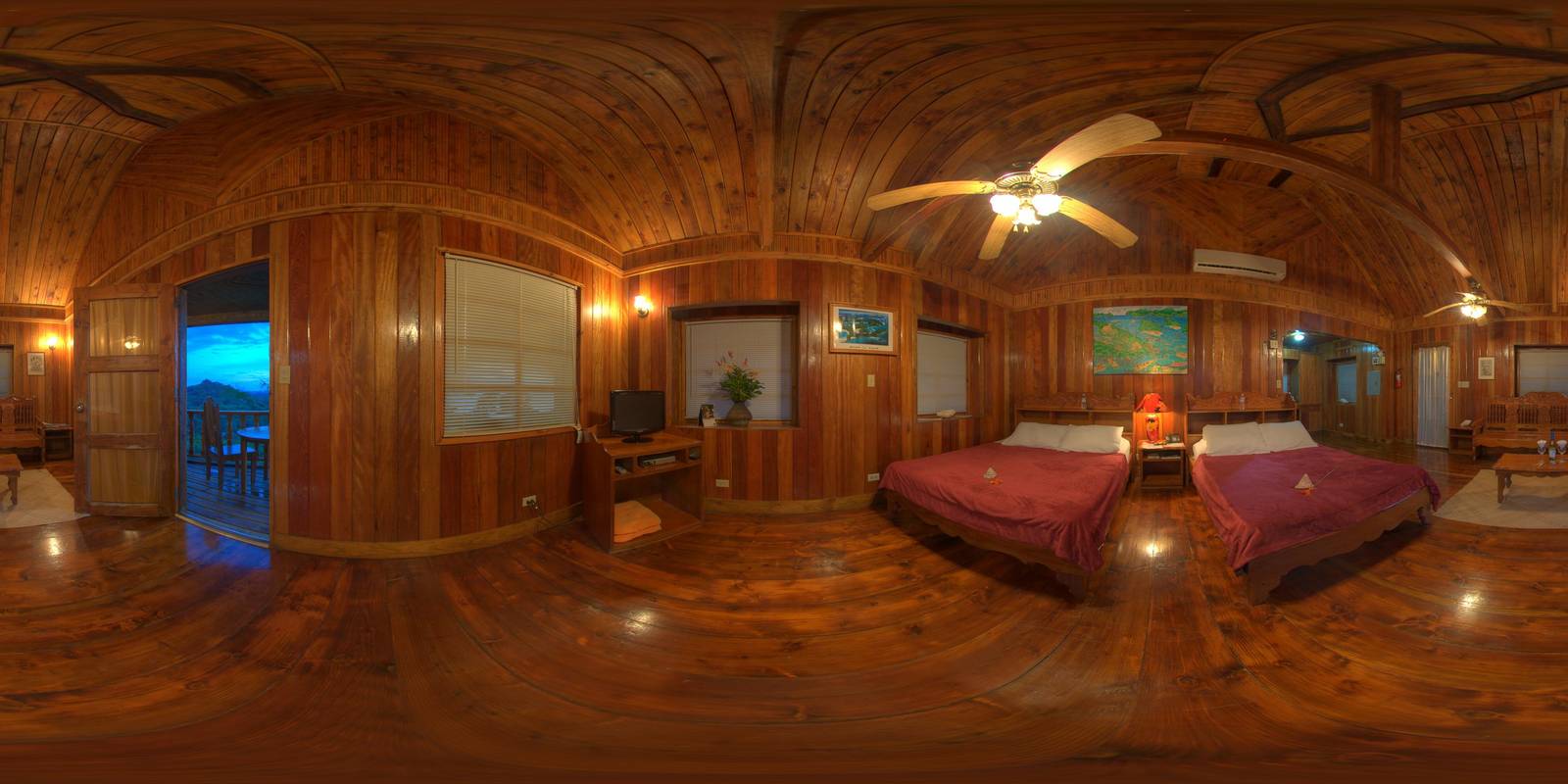 帛琉卡羅琳度假村木屋客房全景，兩張酒紅床鋪、弧形木樑天花與通往暮色陽台的木門