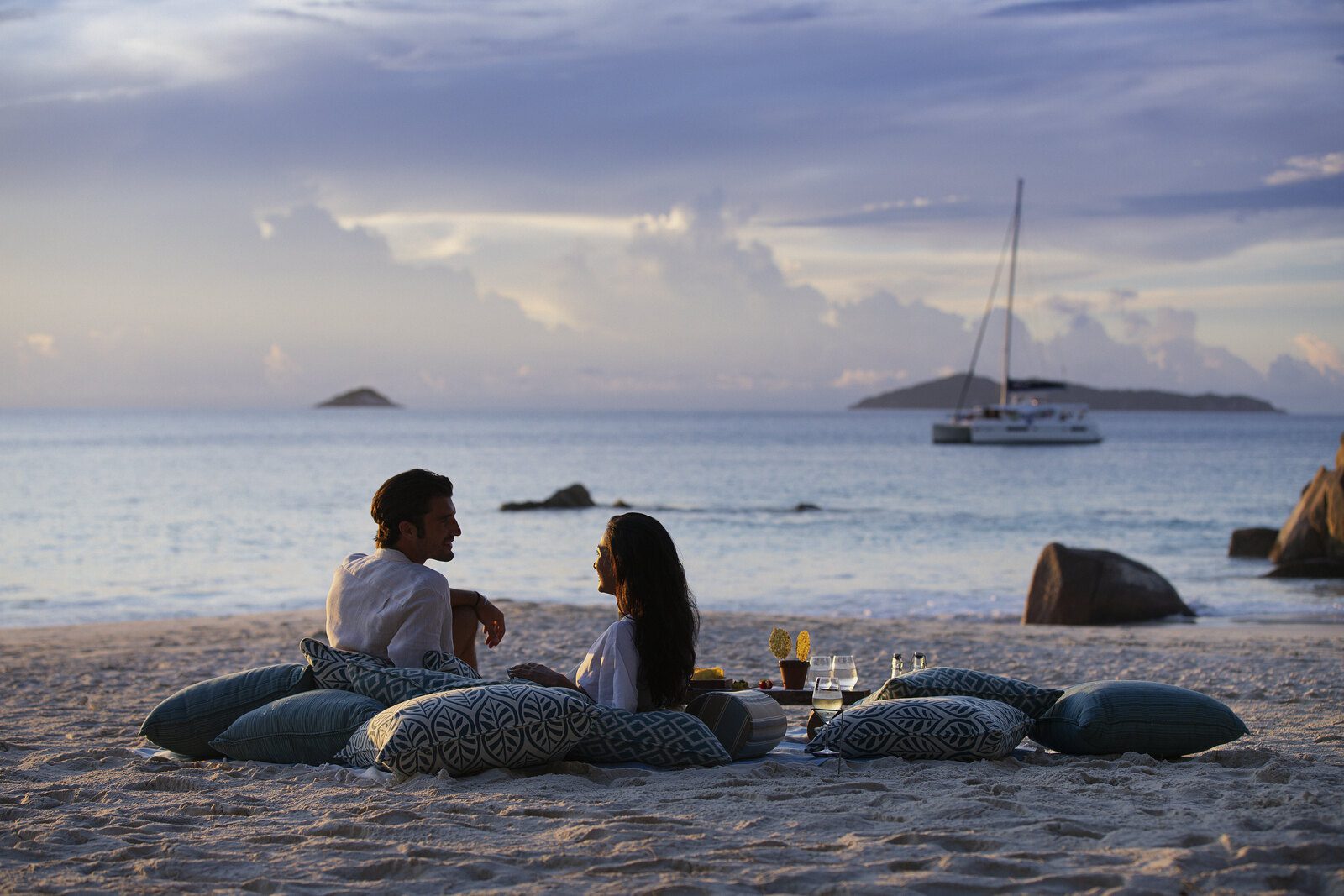 旅客在 Raffles Seychelles 海岸花崗岩旁欣賞日落