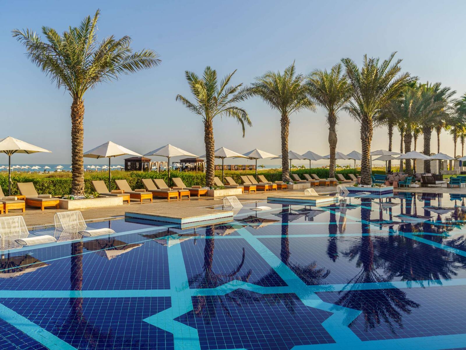 阿布達比薩迪亞特島 Rixos Premium 的戶外泳池與躺椅