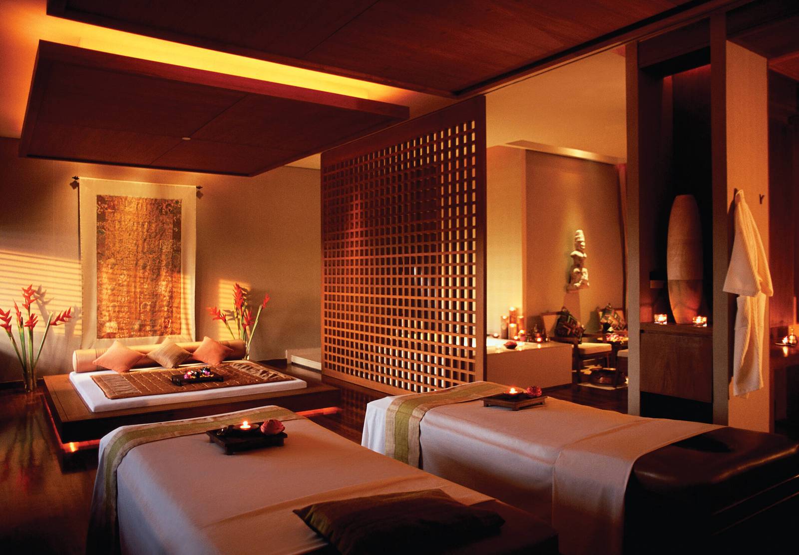 曼谷香格里拉酒店 Chi, The Spa 護理室：暖色木格牆、按摩床與柔和燈光