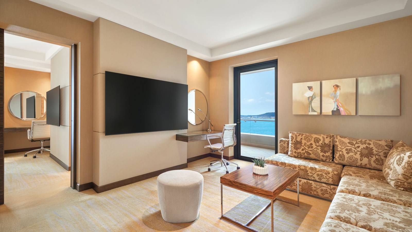 芽莊喜來登 Executive Suite 客廳,L 型沙發、電視與落地窗望向海灣