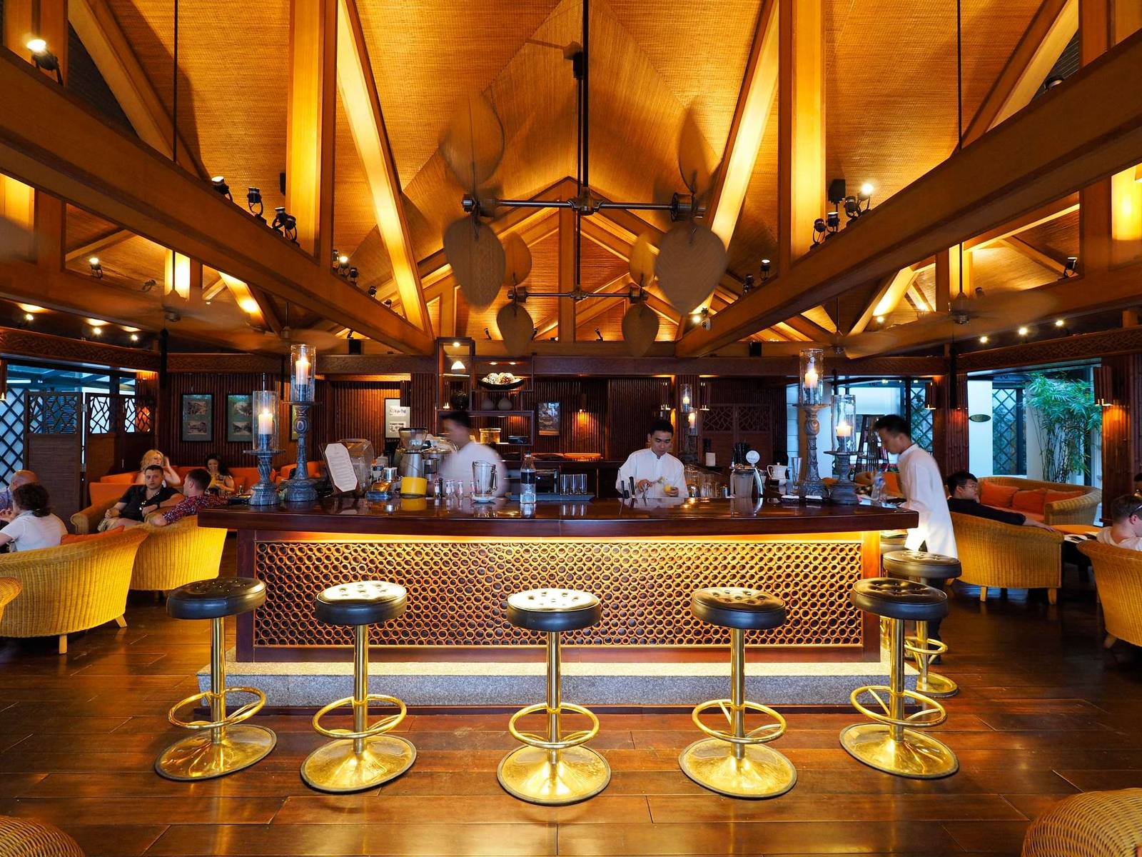 河內索菲特傳奇大都會酒店 Bamboo Bar,竹編頂酒吧、金色圓凳與吧台後的調酒區