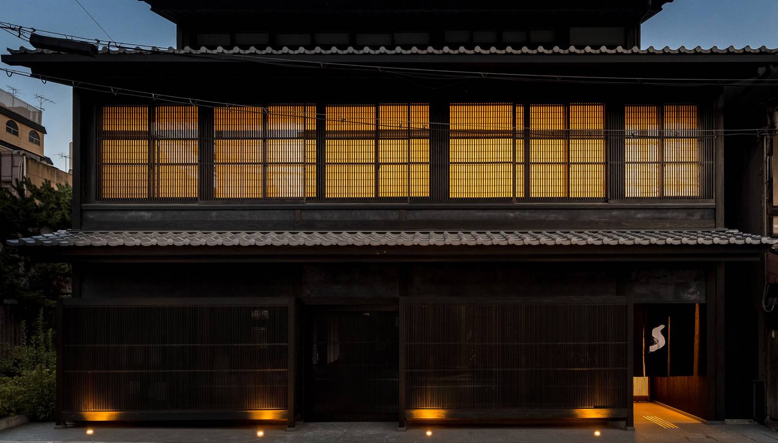 The Shinmonzen 新門前通的深色木造立面與夜間燈光