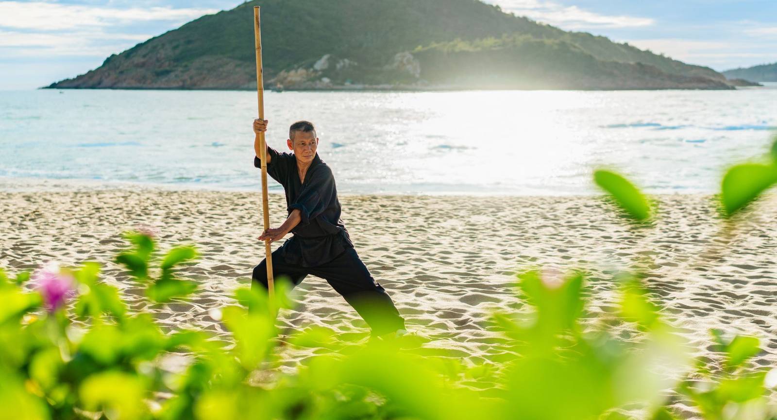 在沙灘上練習棍術的武術師