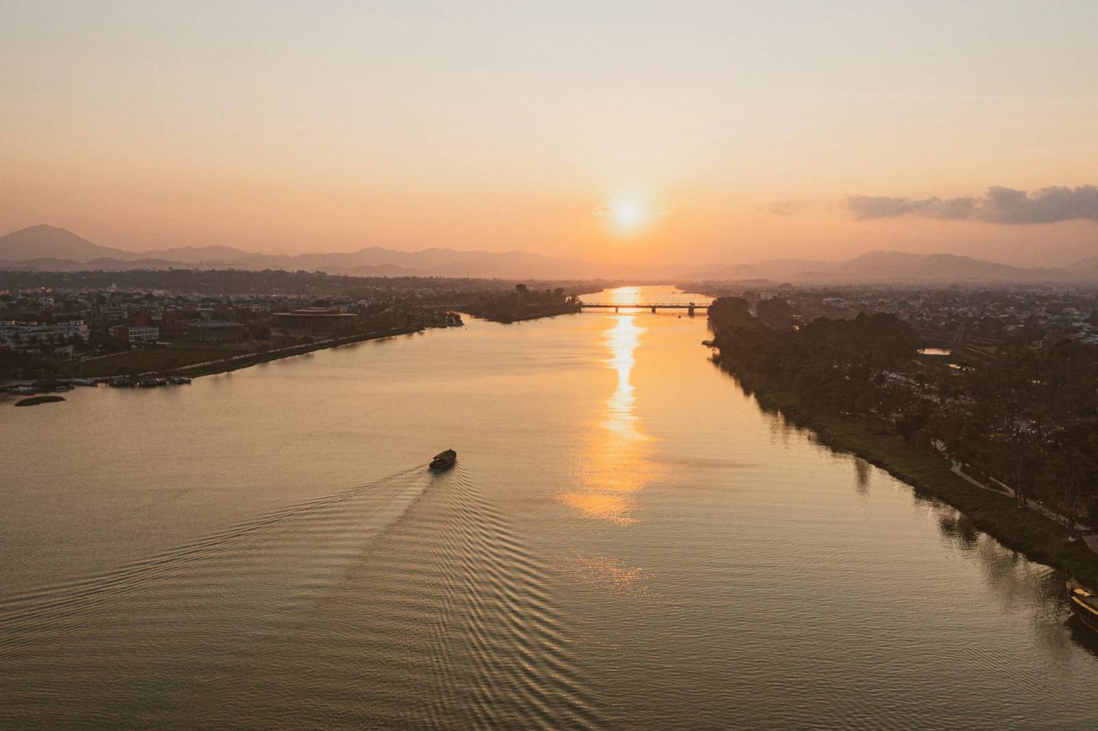 夕陽下的寬闊河面、遠山與橋