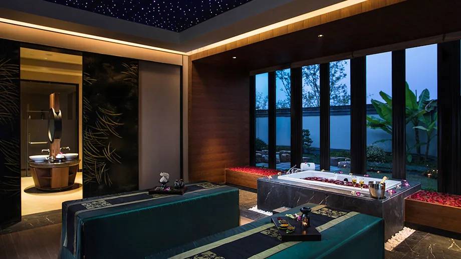 安吉悅榕庄 Spa 療程室的浴池與窗外綠意