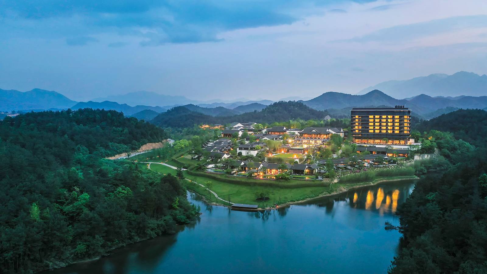 安吉悅榕庄傍晚空拍,湖畔建築群與遠方群山