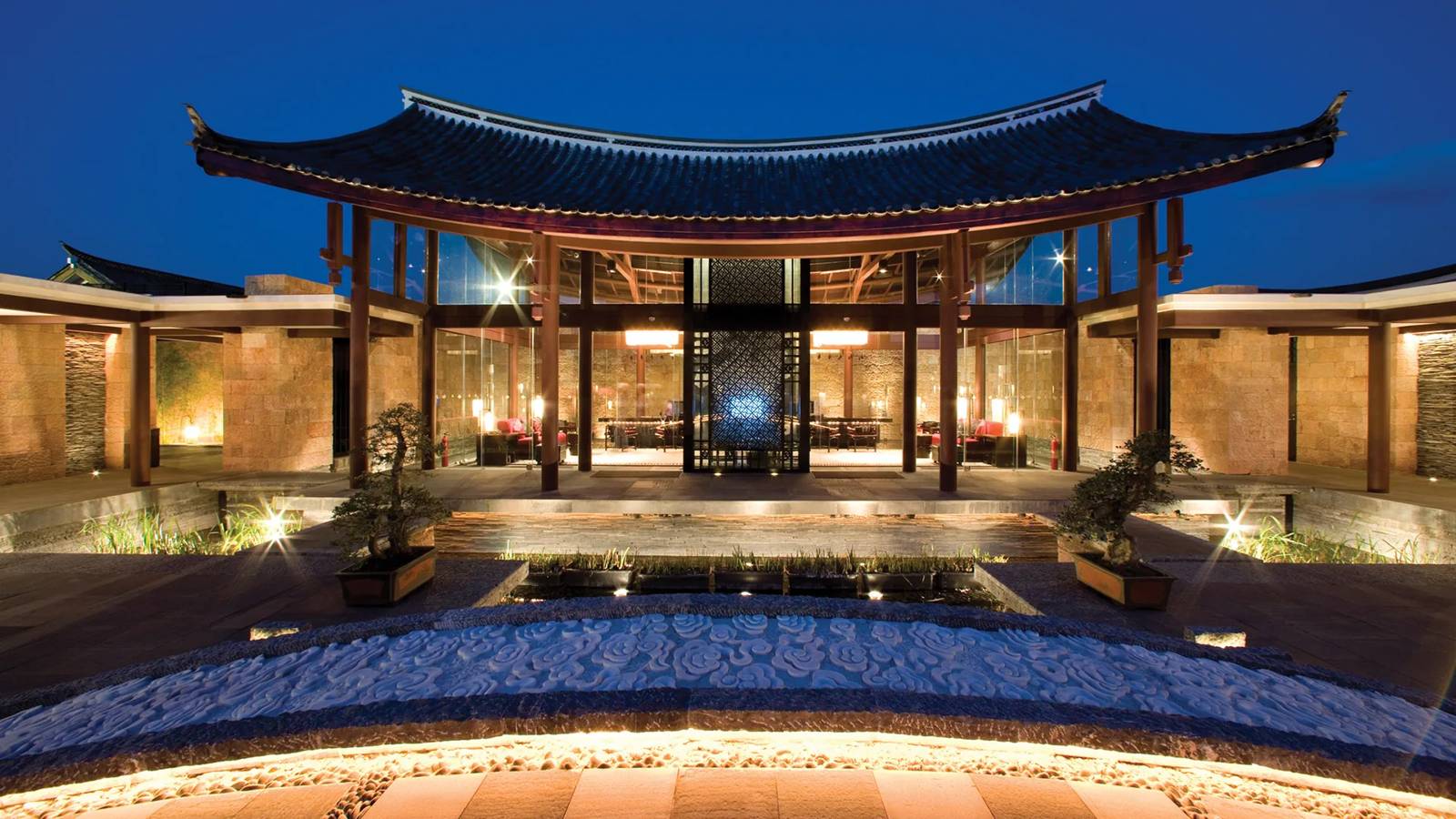 麗江悅榕庄夜間點燈的納西式大屋頂建築與庭院水景