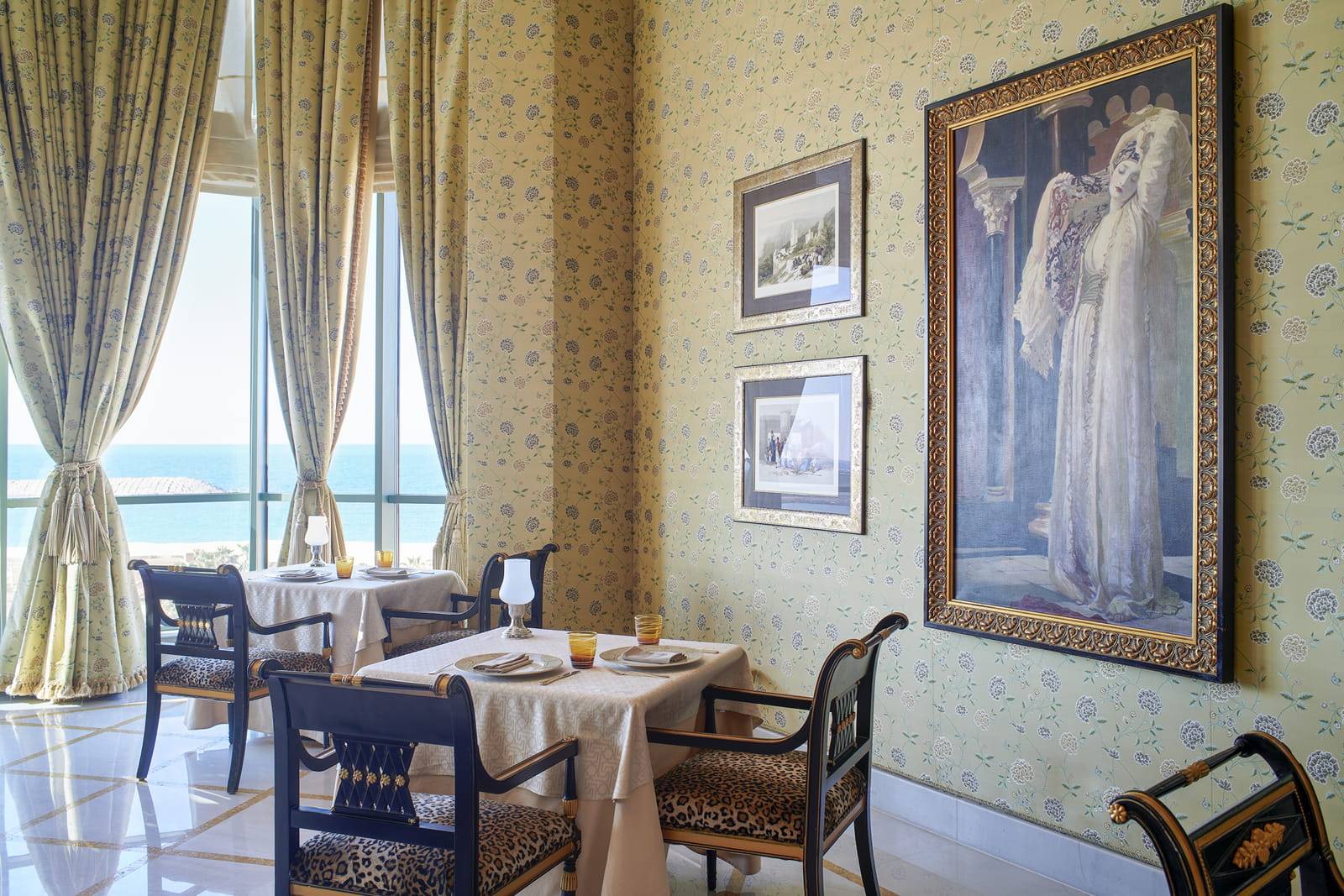 亞歷山大四季酒店 Byblos 餐廳的金色窗簾、餐桌與海景
