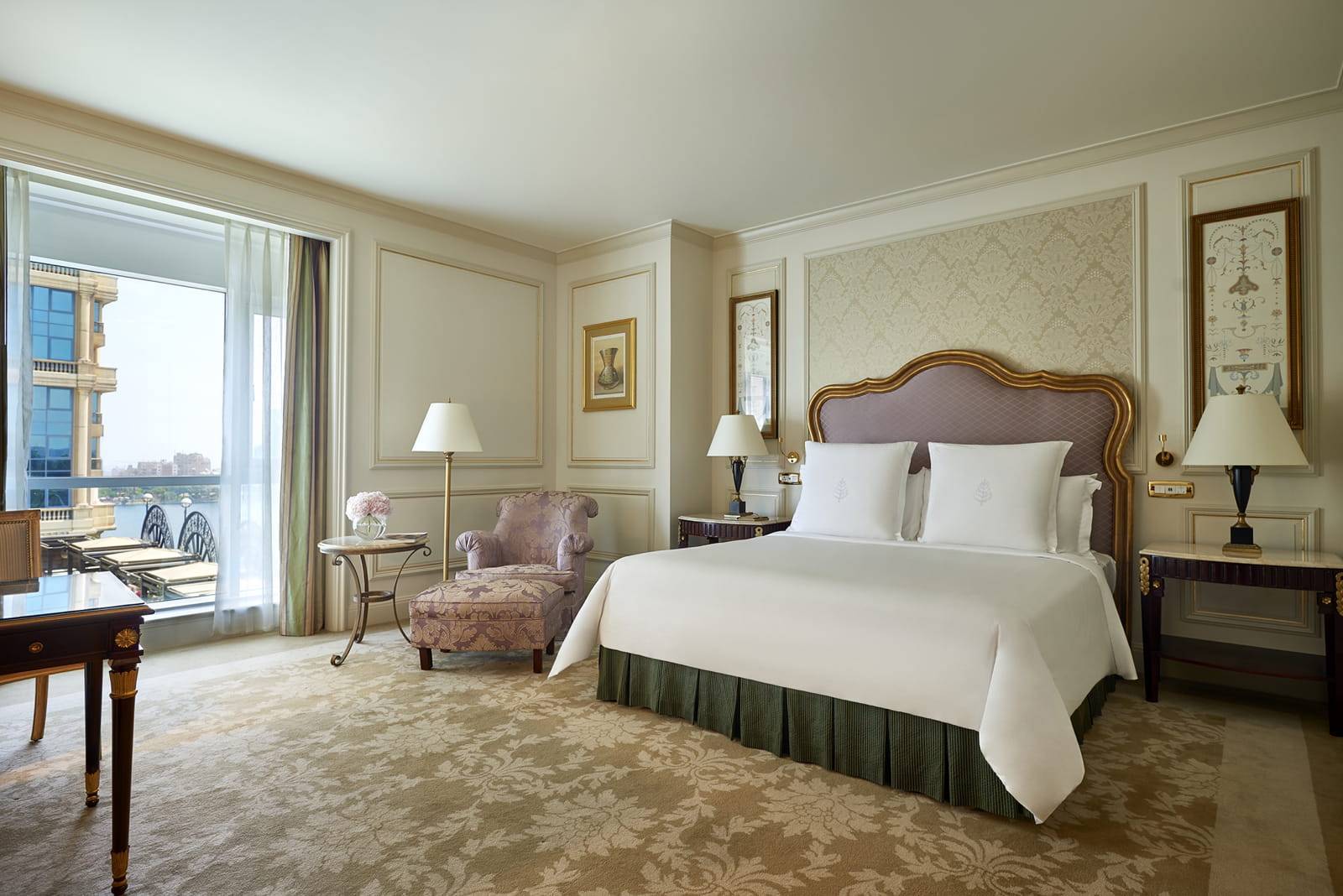 開羅第一居庭四季酒店 Deluxe Room 的大床、扶手椅與落地窗