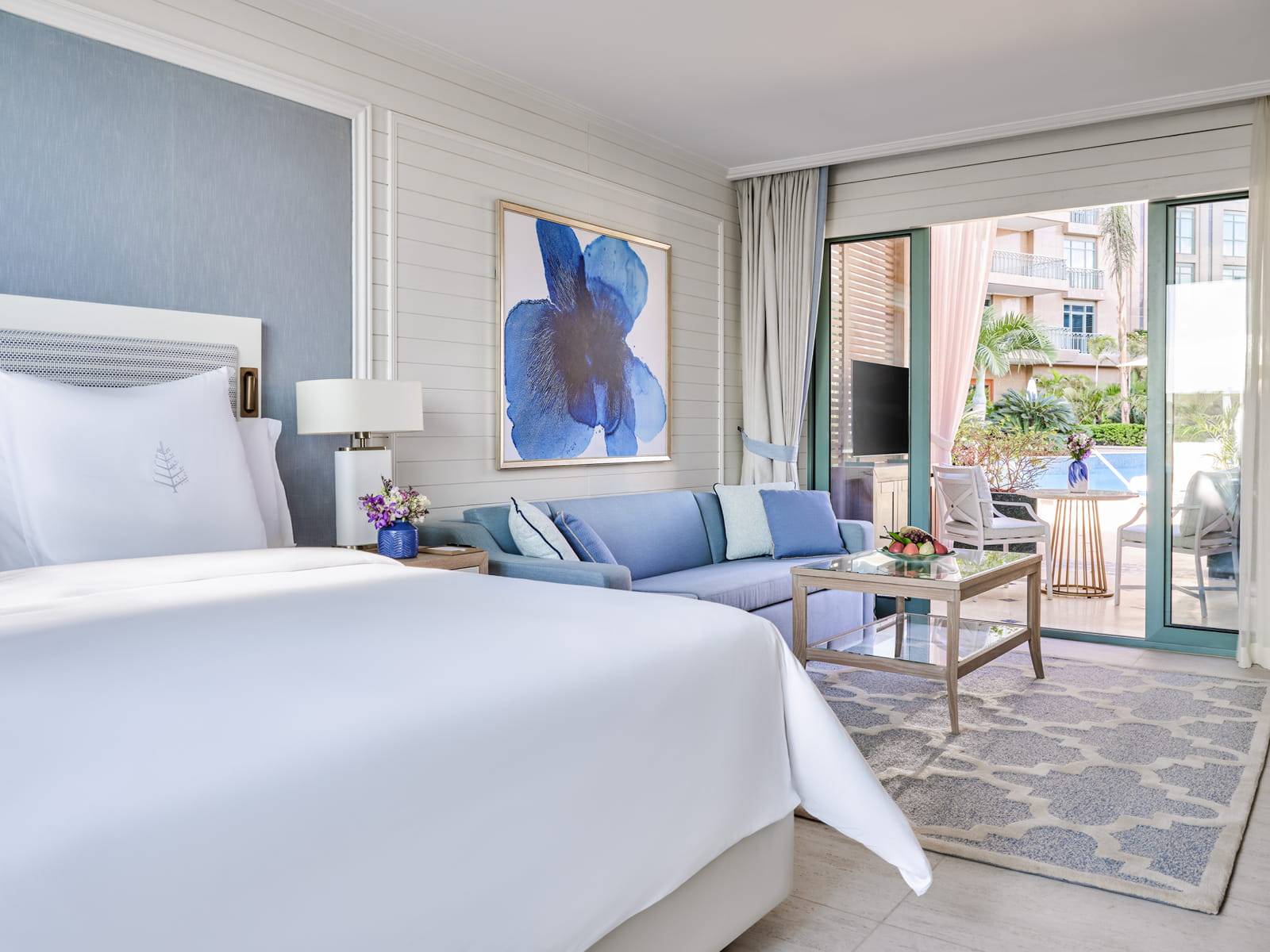 開羅尼羅河廣場四季酒店 Pool Terrace Room 的大床、藍色沙發與露台門