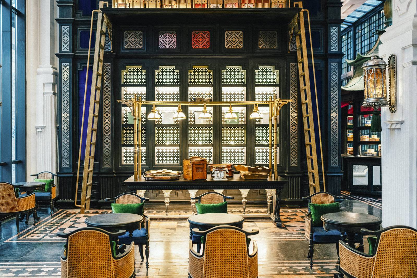 黑色格柵櫃、金色梯架與藤編椅的甜點店