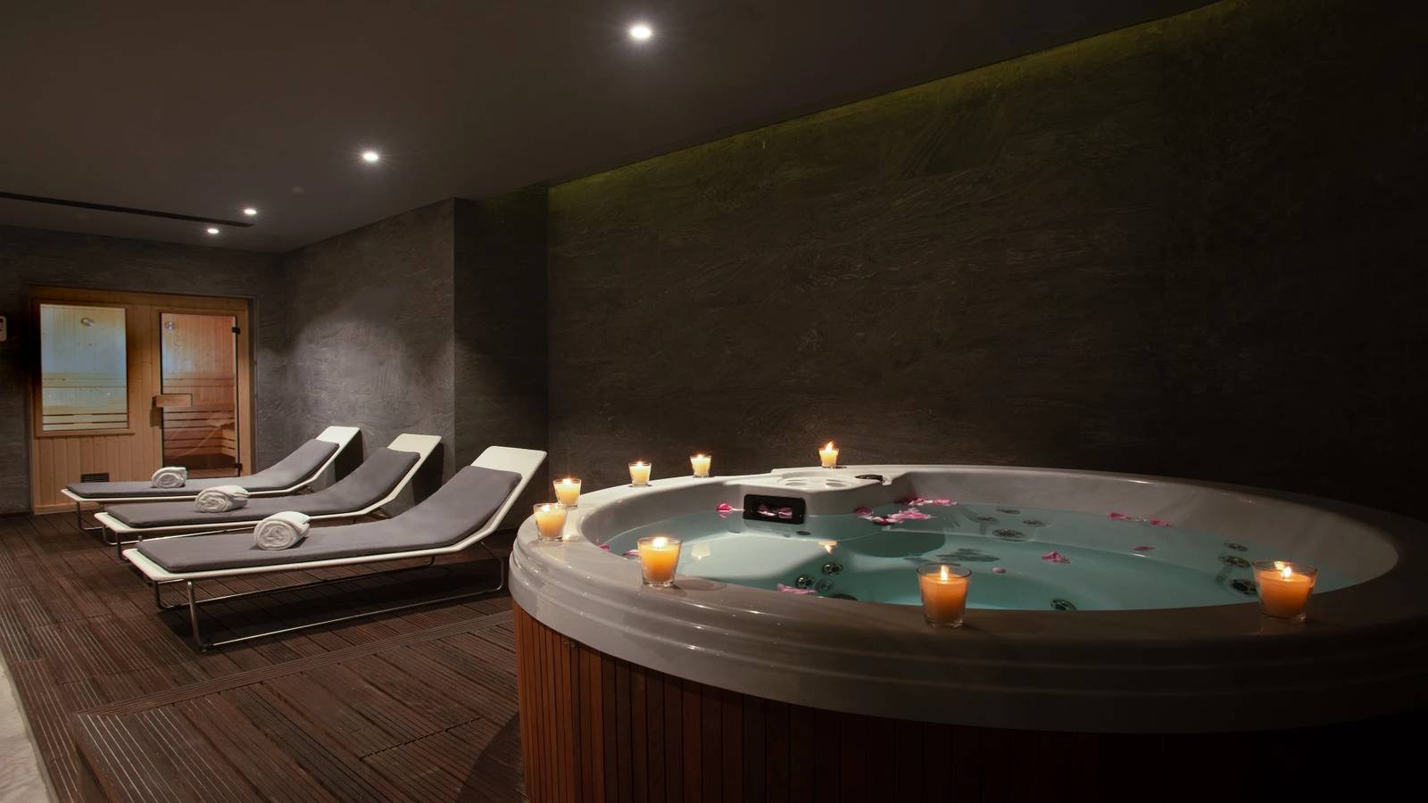開羅塞米勒米斯洲際酒店 Spa 熱療區的按摩池與躺椅，池邊點著蠟燭