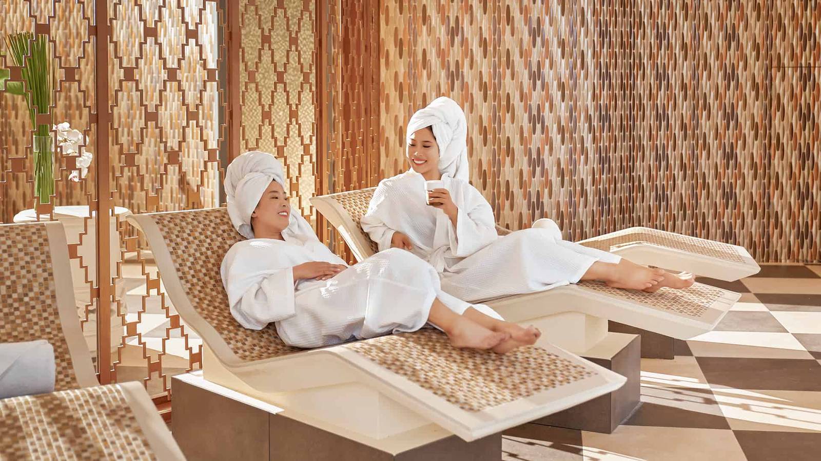 穿著浴袍在 Spa 躺椅上休息的兩位旅客